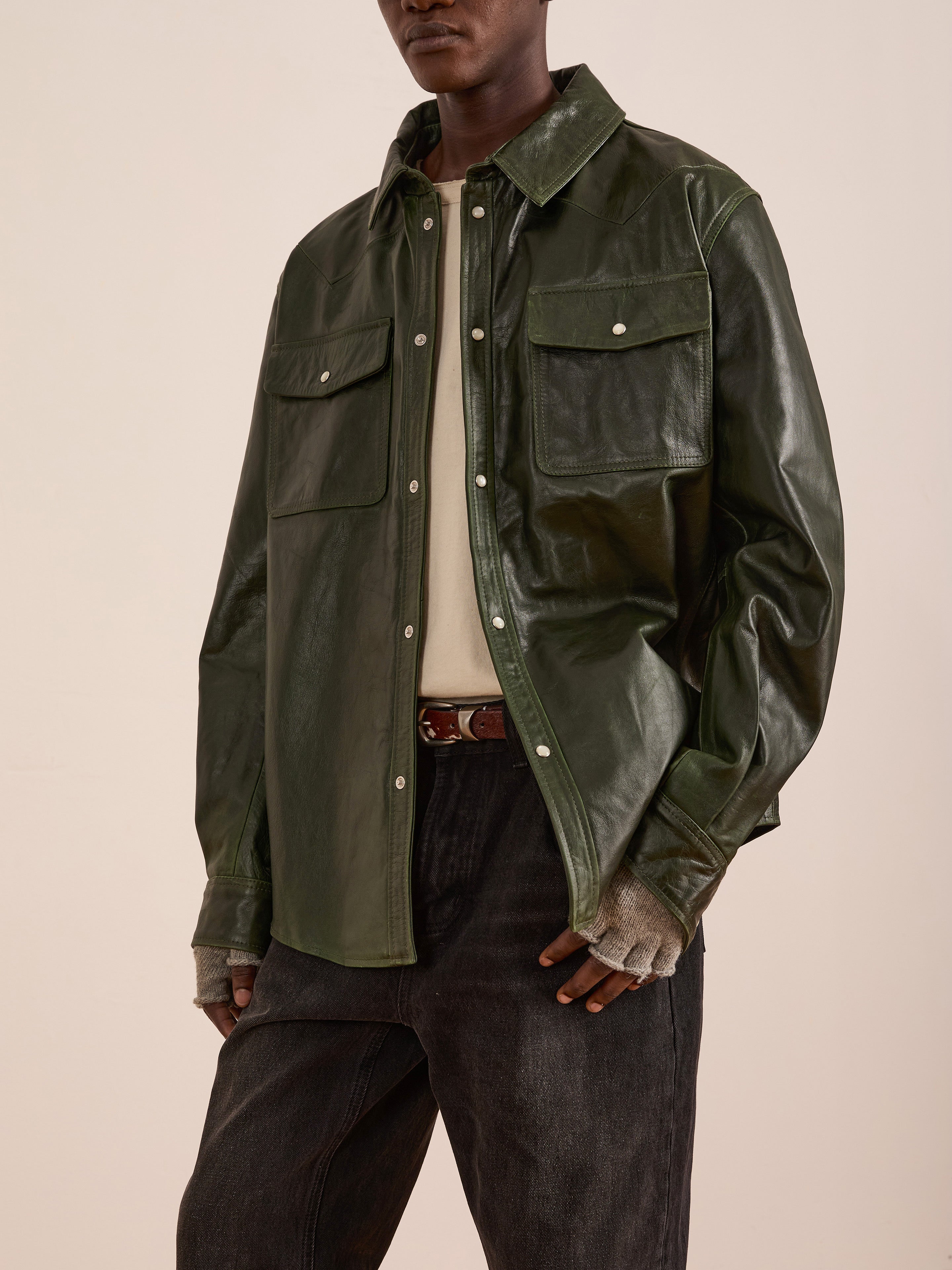 A person models the FOUND Forest Leather Western Shirt over a beige top with dark pants and fingerless gloves, standing against a neutral background.