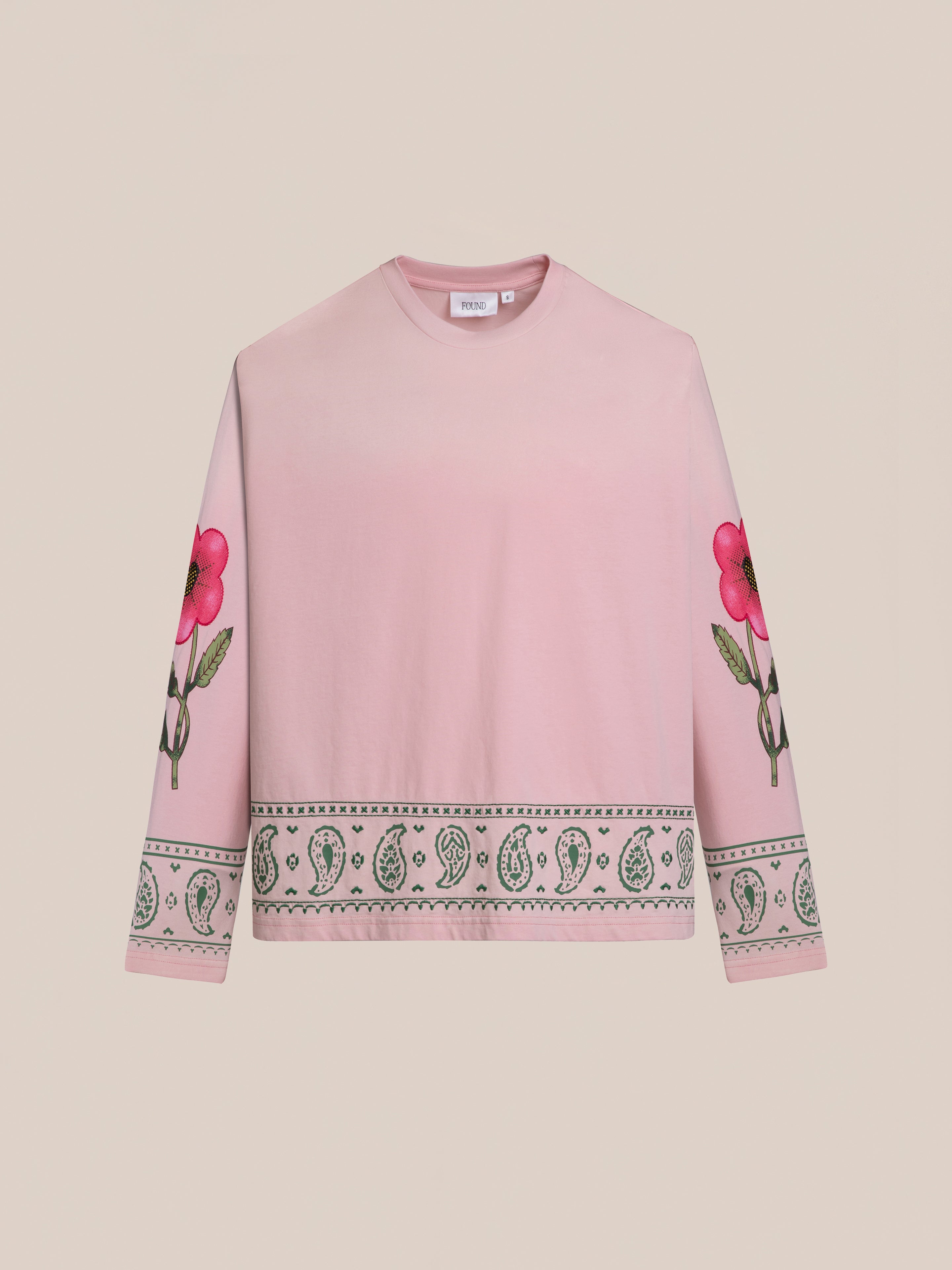 The FOUND Garden Bloom Embroidered LS Tee is a unisex relaxed fit pink long-sleeve shirt with floral sleeve graphics and a patterned border on the hem and cuffs.