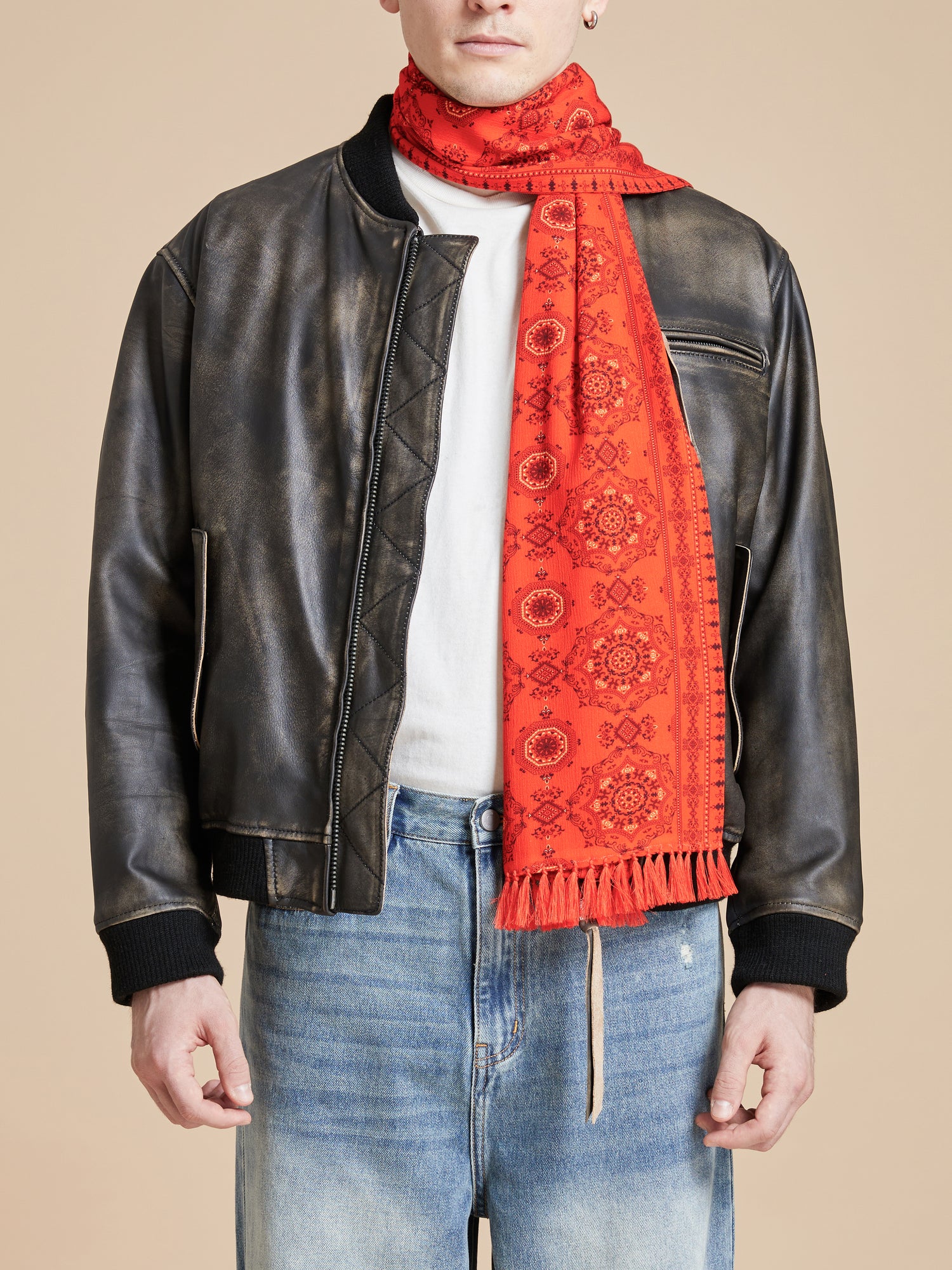 A man wearing a Found Grenadine Scarf and leather jacket.