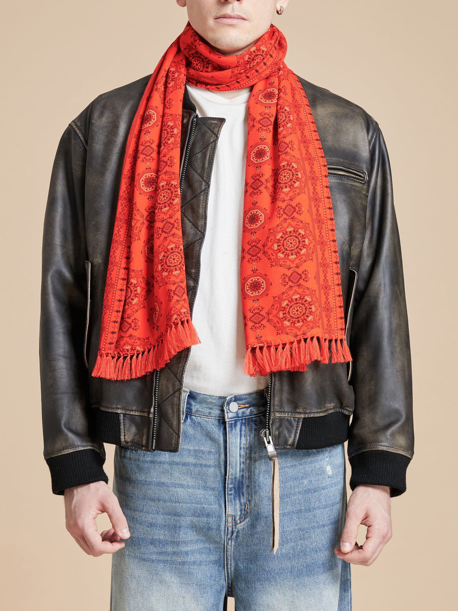 A man wearing a Grenadine Scarf by Found with hand tied tassels.
