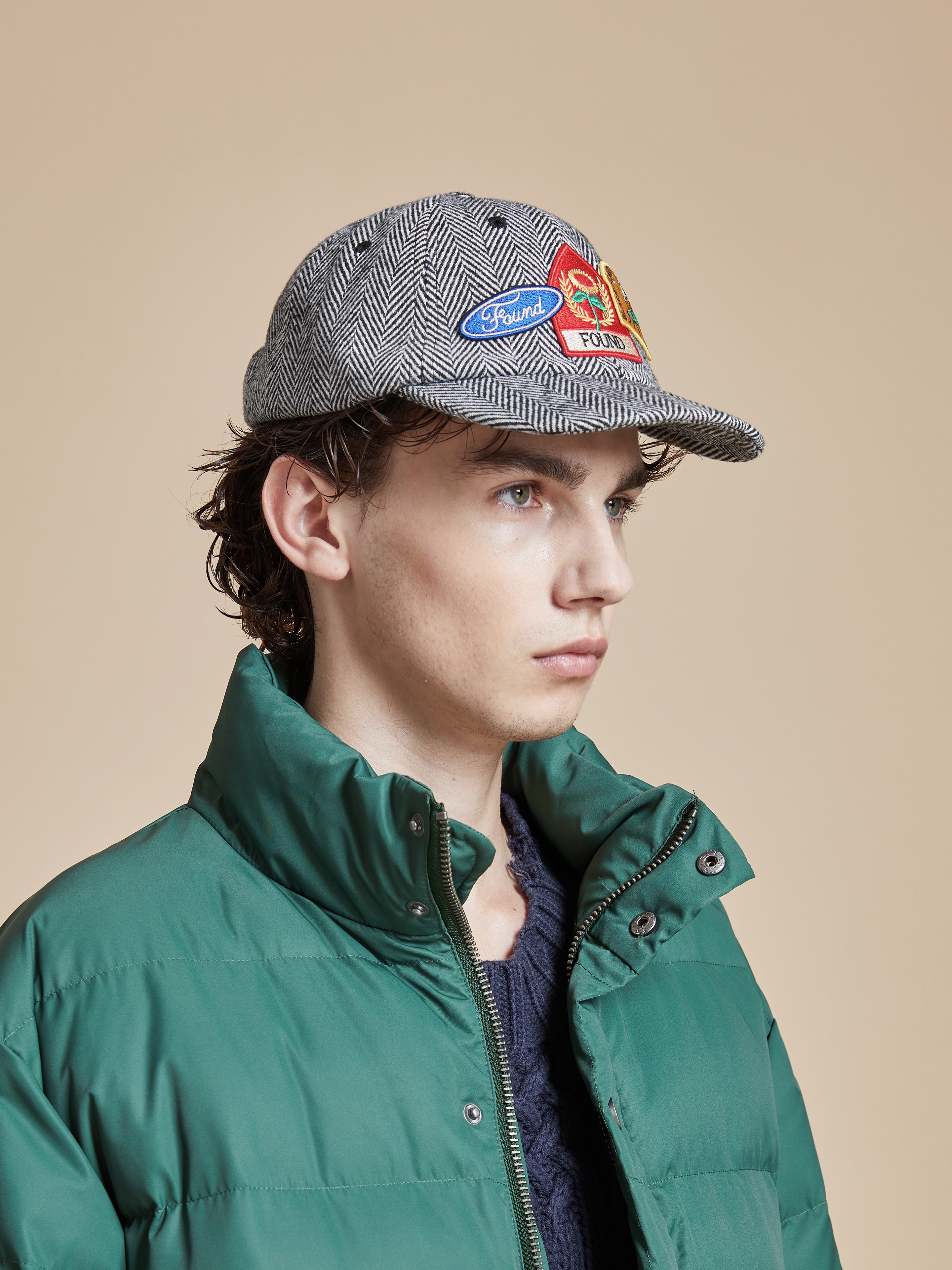 A man in a grey Found Herringbone Tweed Patch Cap and jacket.