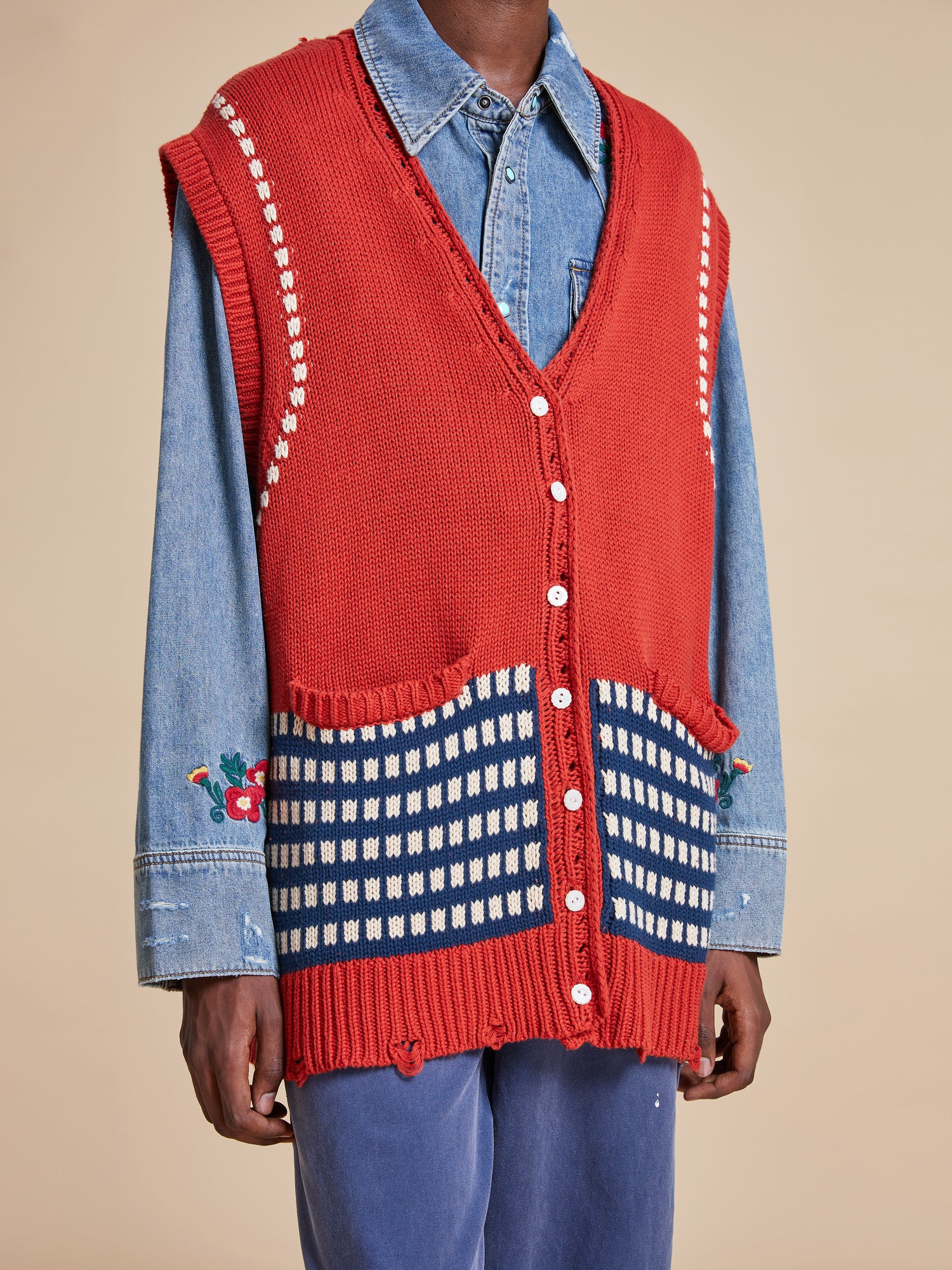 A man wearing a Found Homestead Check Sweater Knit Vest and jeans.