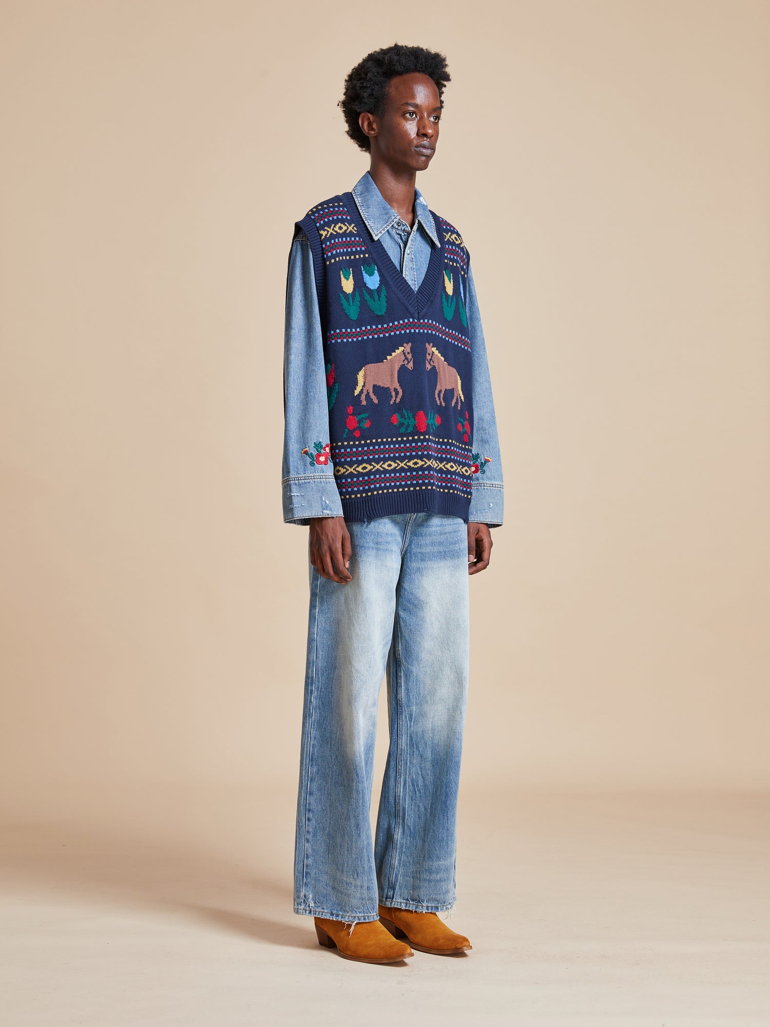The model is wearing a Isle Horse Reverie Sweater Knit Vest by Found and jeans.