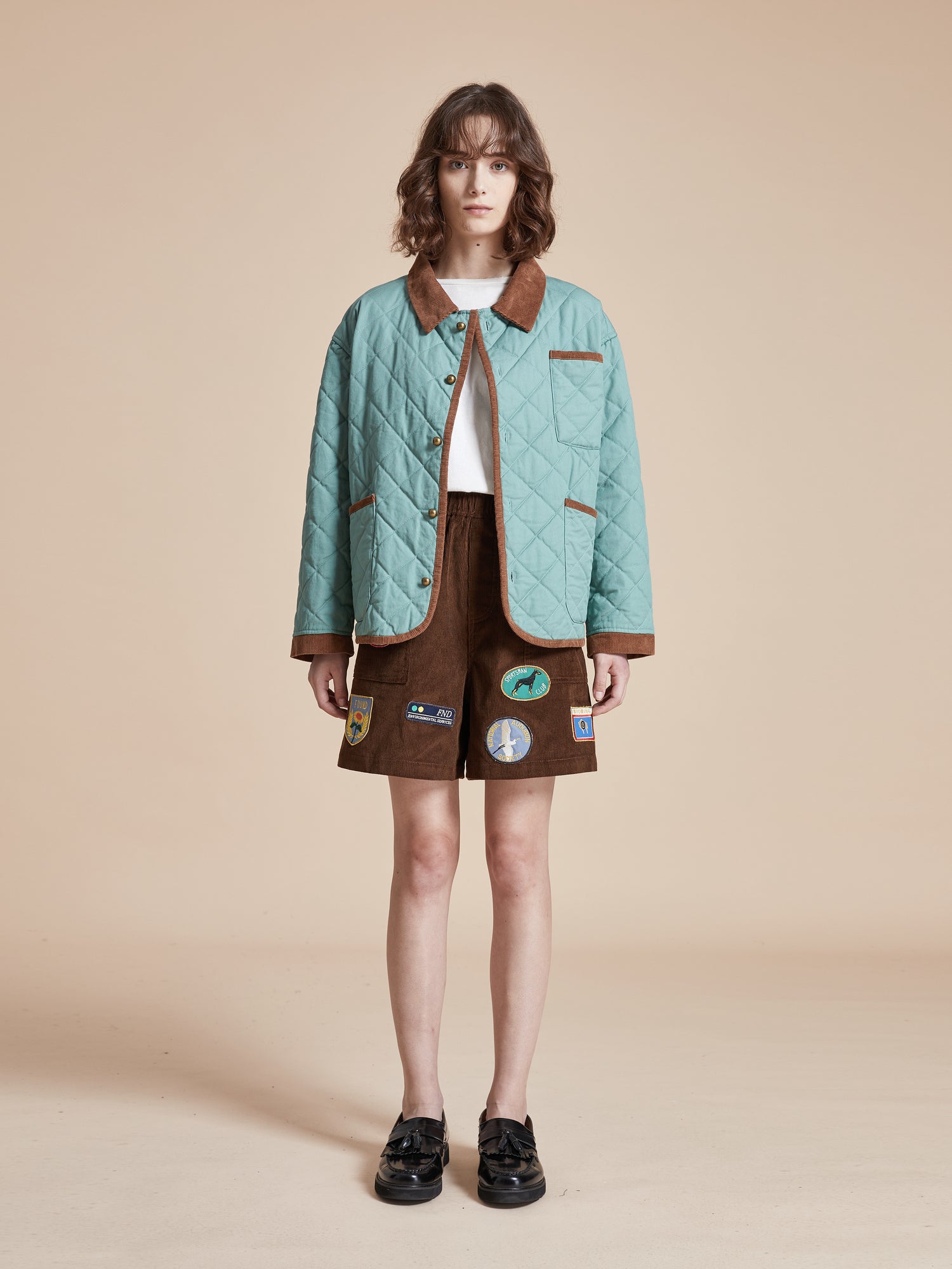 A model wearing a Kashmir Meadow Quilt Jacket and shorts by Found.