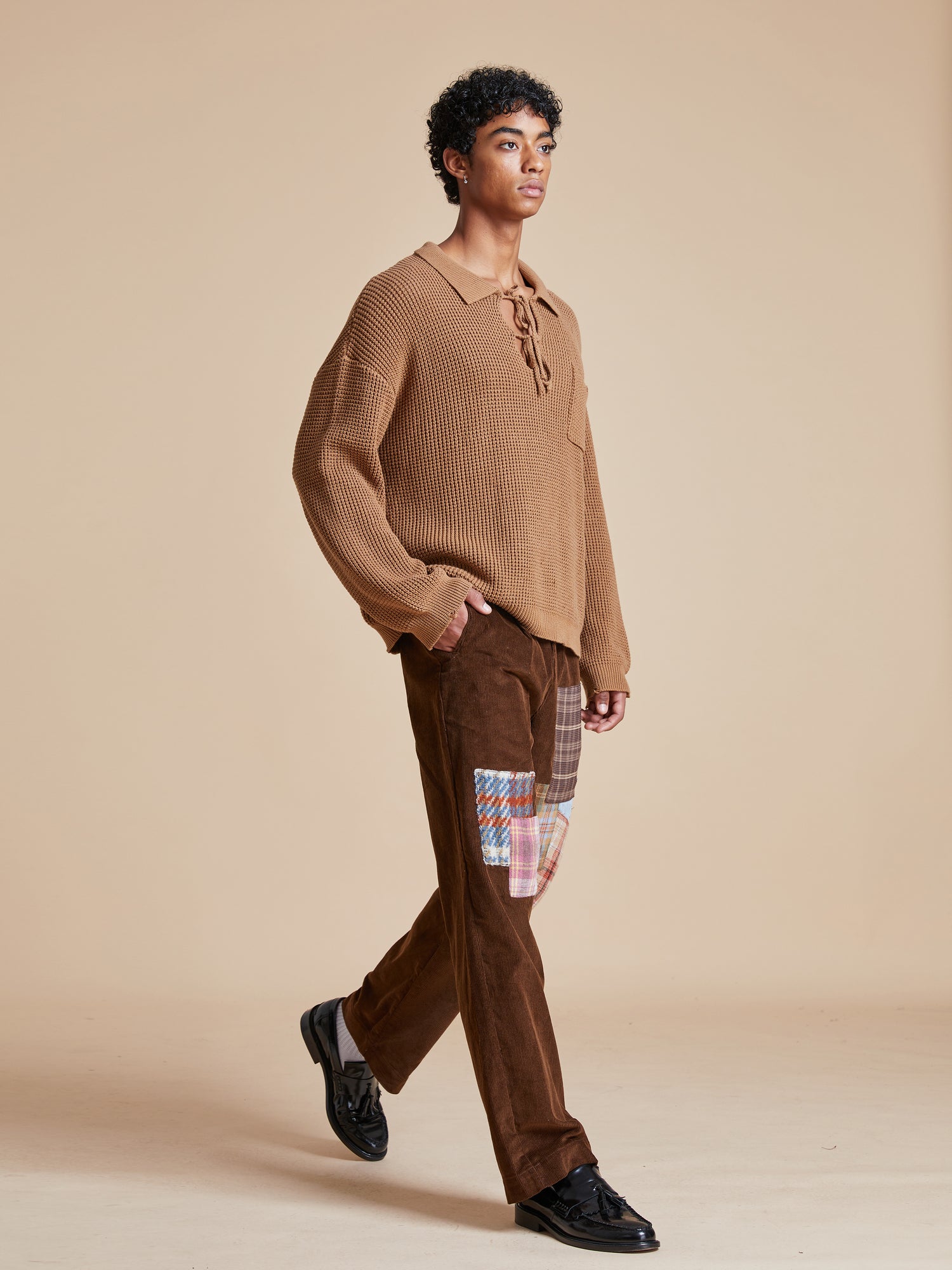 The model is wearing a ginger-colored Tie-Collar Knit Sweater from Found with a cozy feel.