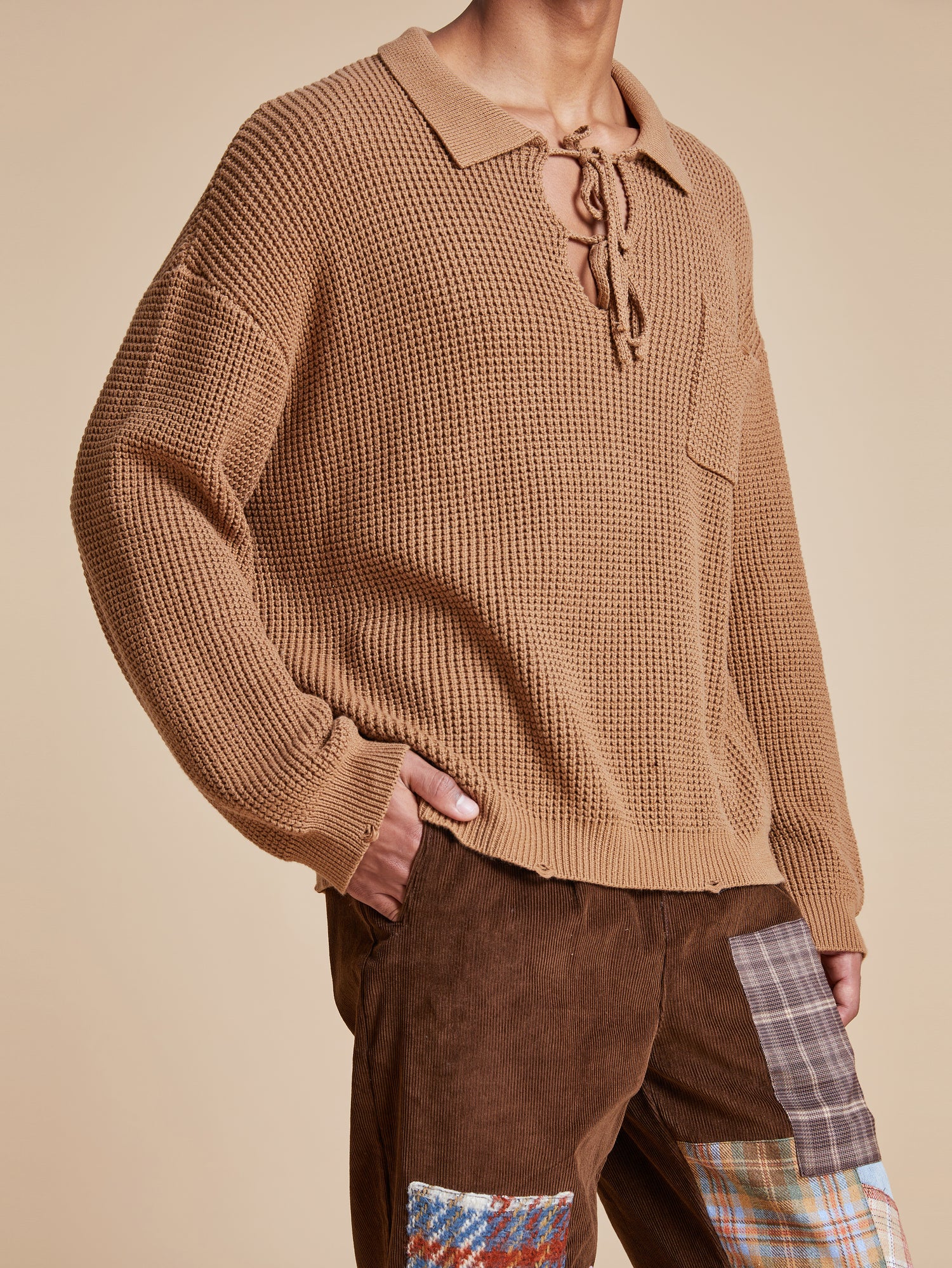 A man wearing a ginger-colored Found Tie-Collar Knit Sweater with cozy feel.