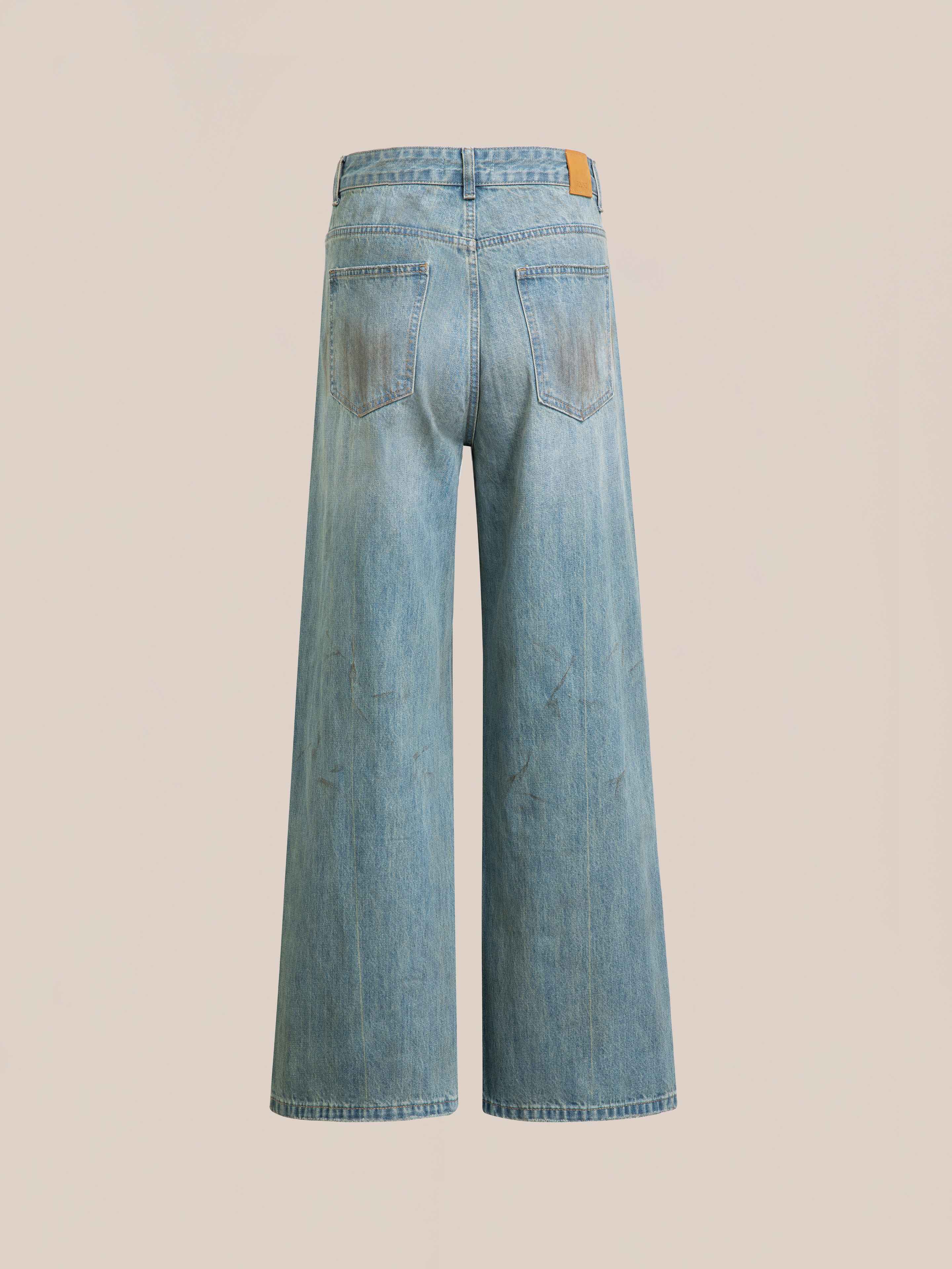 Back view of FOUND Lacy Baggy Jeans in light blue denim, featuring two rear pockets and a tan leather patch on the waistband, displaying their relaxed wide-leg fit against a plain background.