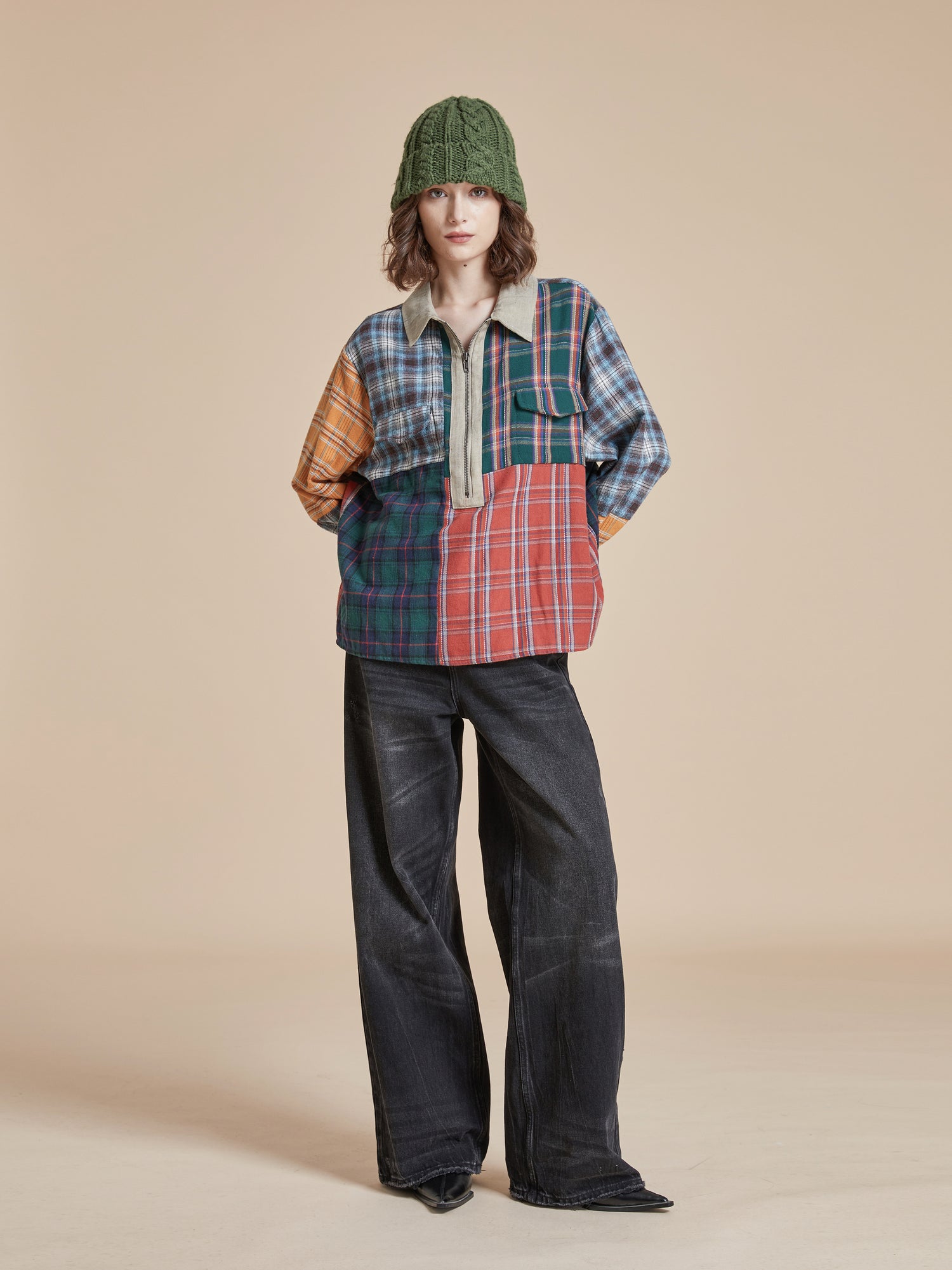 A woman wearing a plaid shirt and black wash, wide-leg Lacy Baggy Jeans with distressed hems by Found.