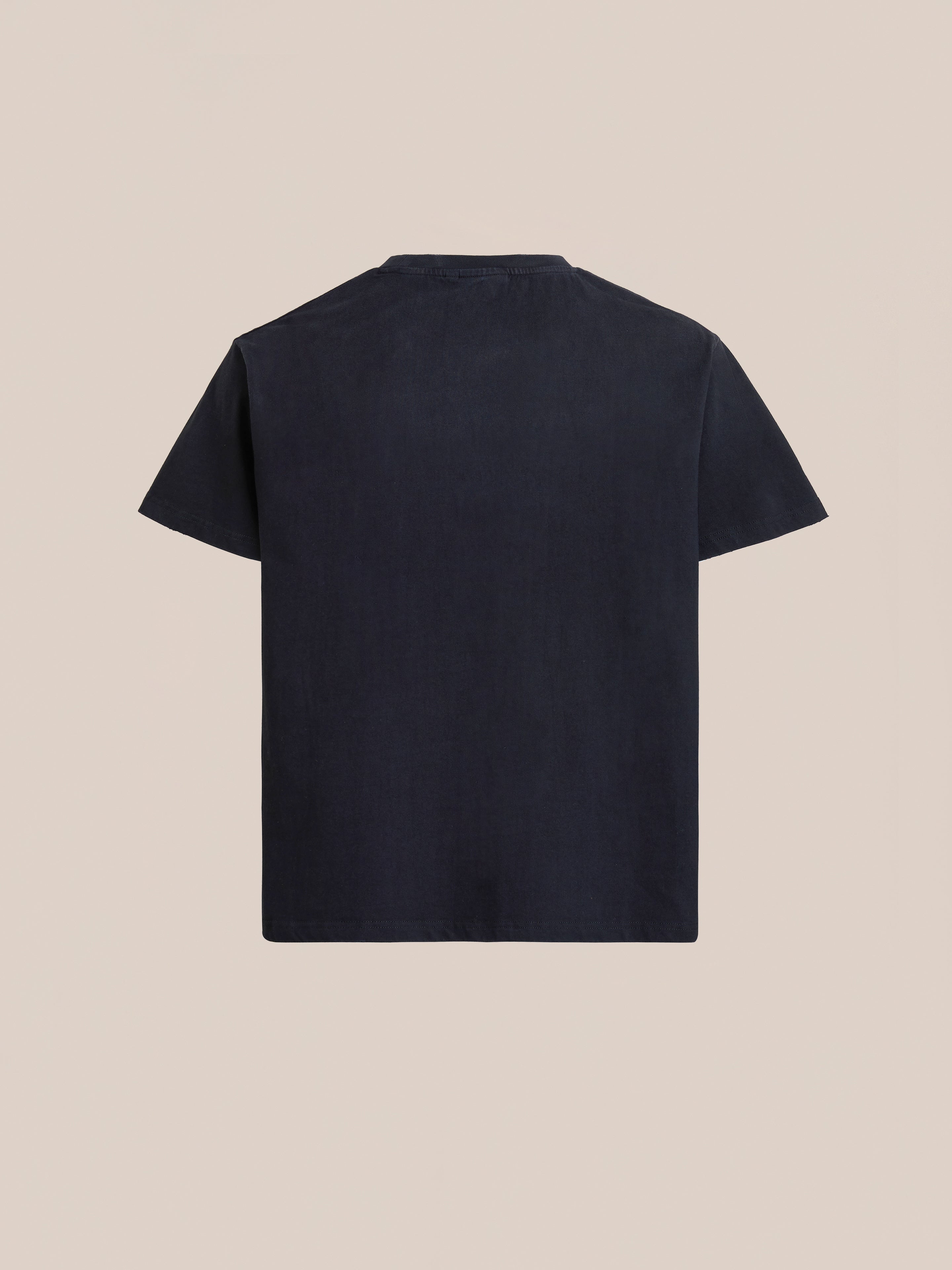 The FOUND Language Tapestry Logo Tee, a vintage-faded black short-sleeve t-shirt, is displayed from the back against a beige background.