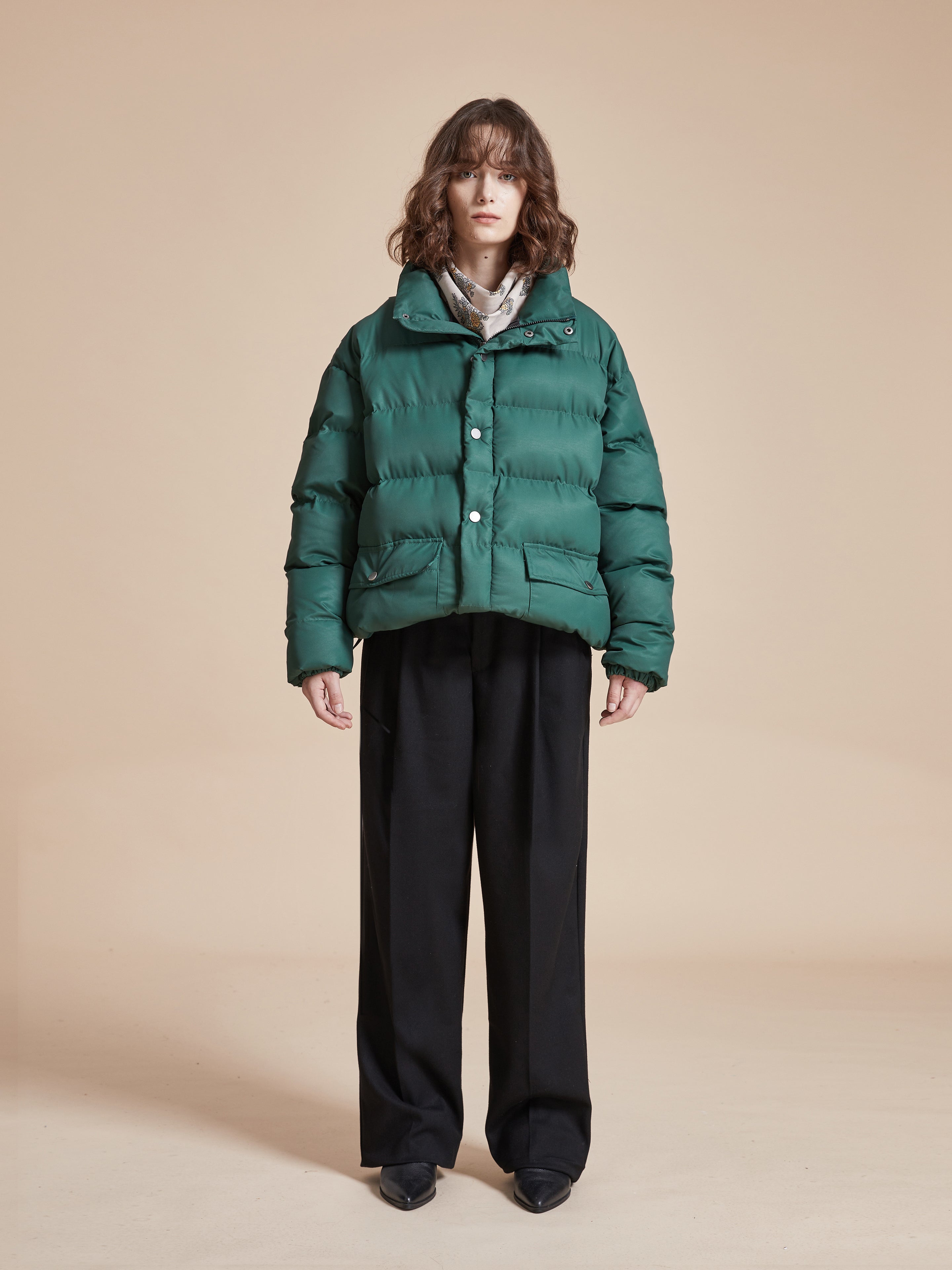 A woman wearing the Found Laurel Pine Puffer Jacket and black pants.