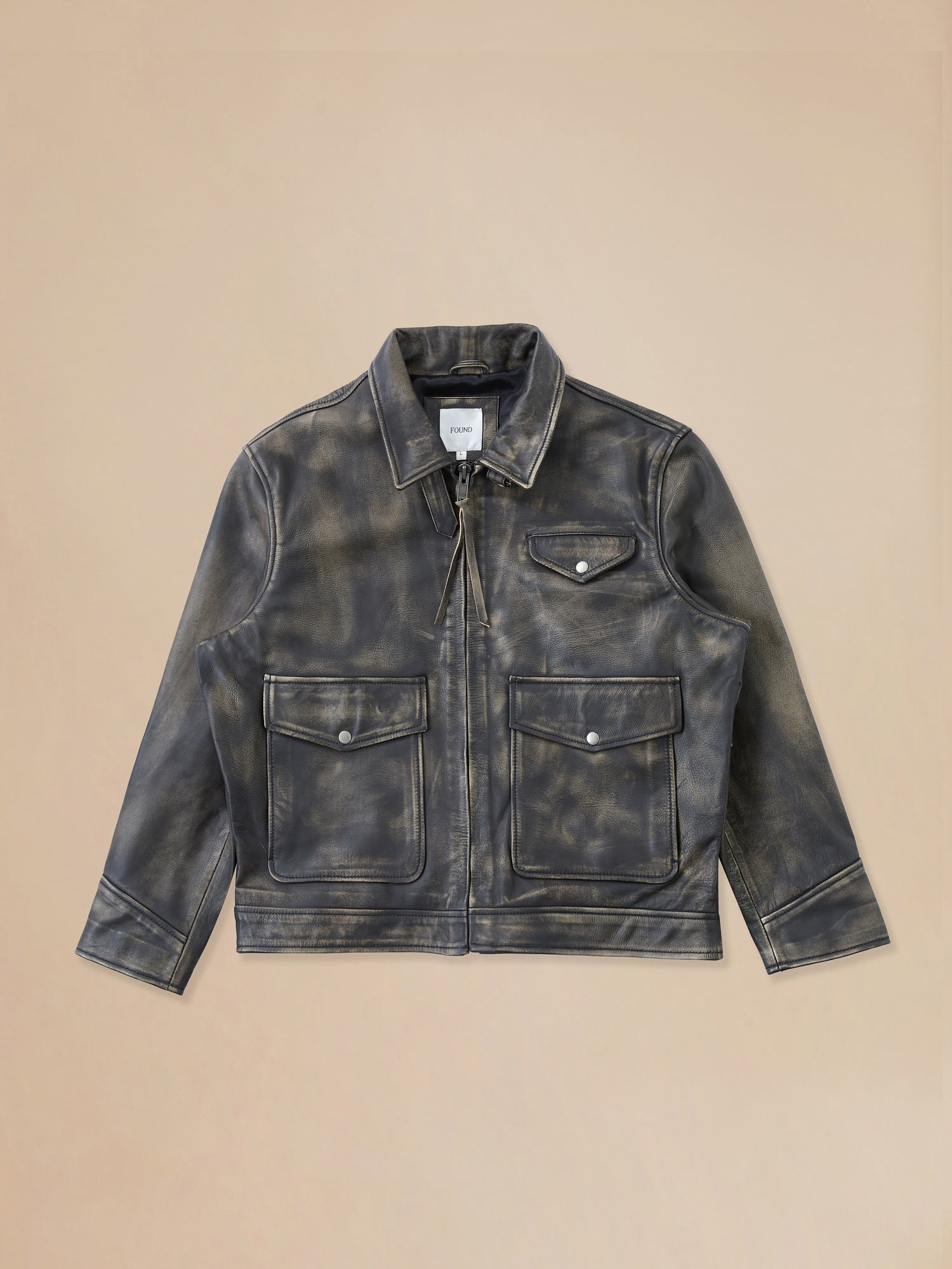 A Found Distressed Leather Pocket Jacket on a beige background.