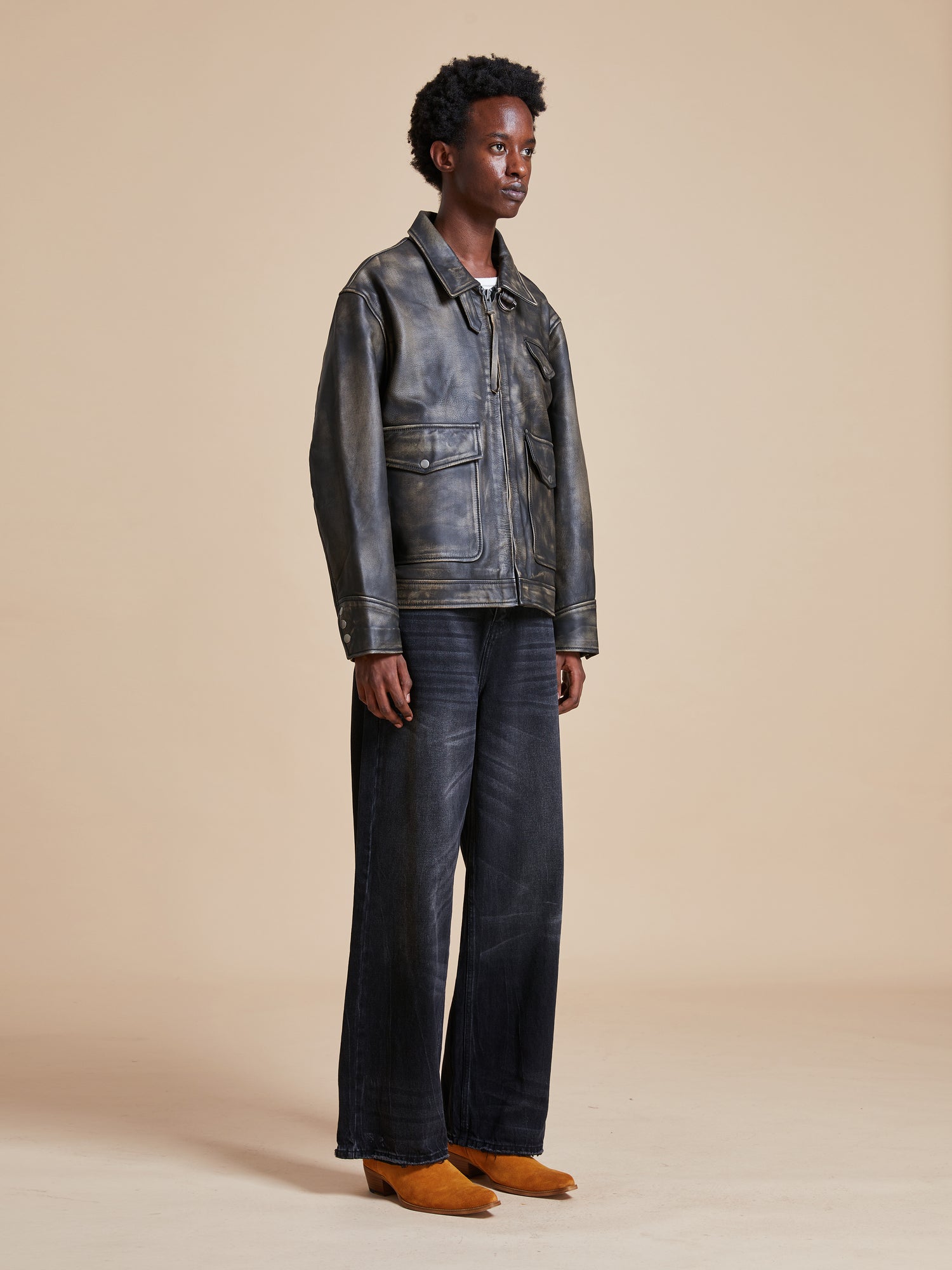 The model is wearing a Found Distressed Leather Pocket Jacket and wide leg pants.