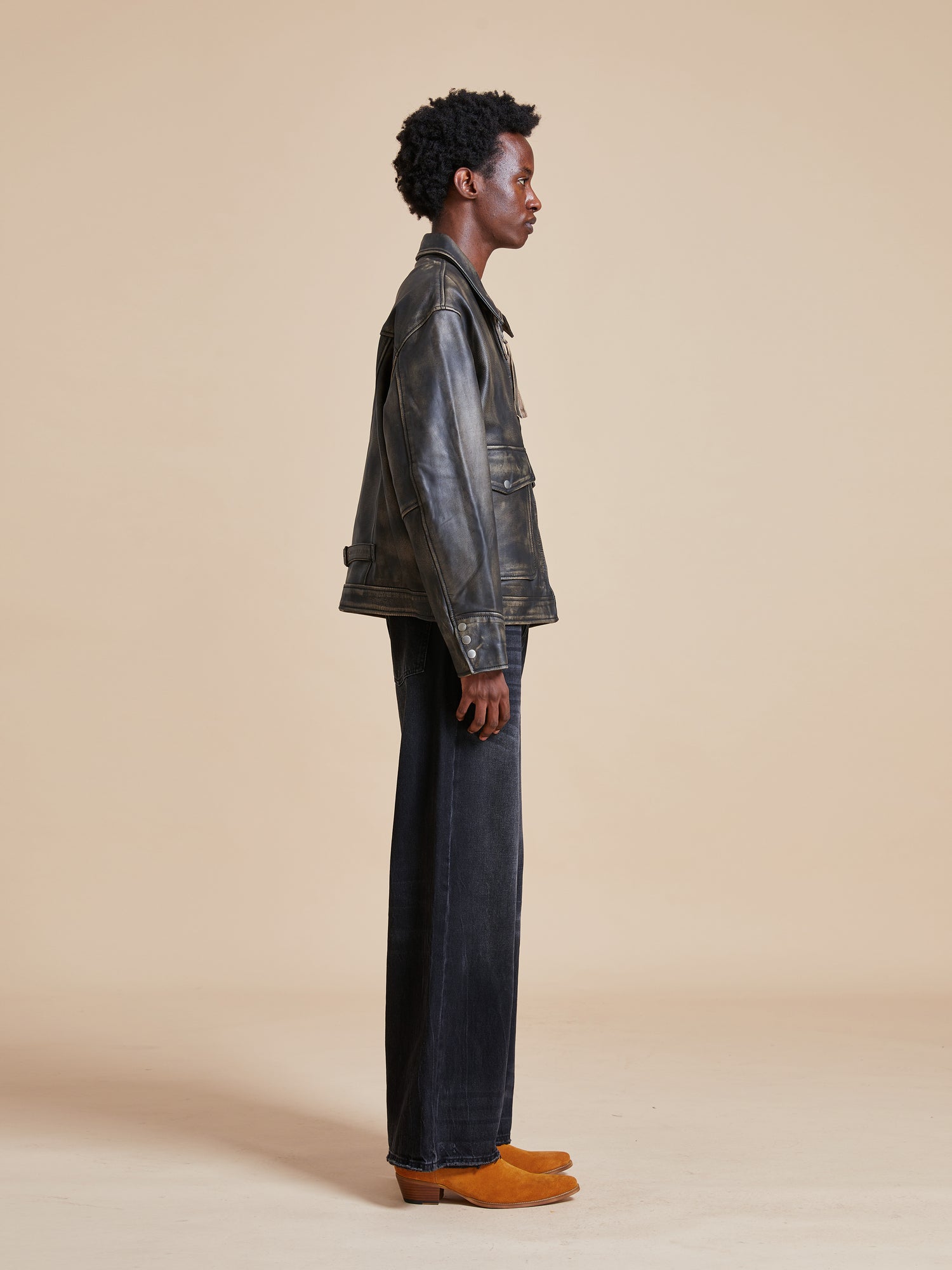 The model is wearing a Found Distressed Leather Pocket Jacket and black pants.