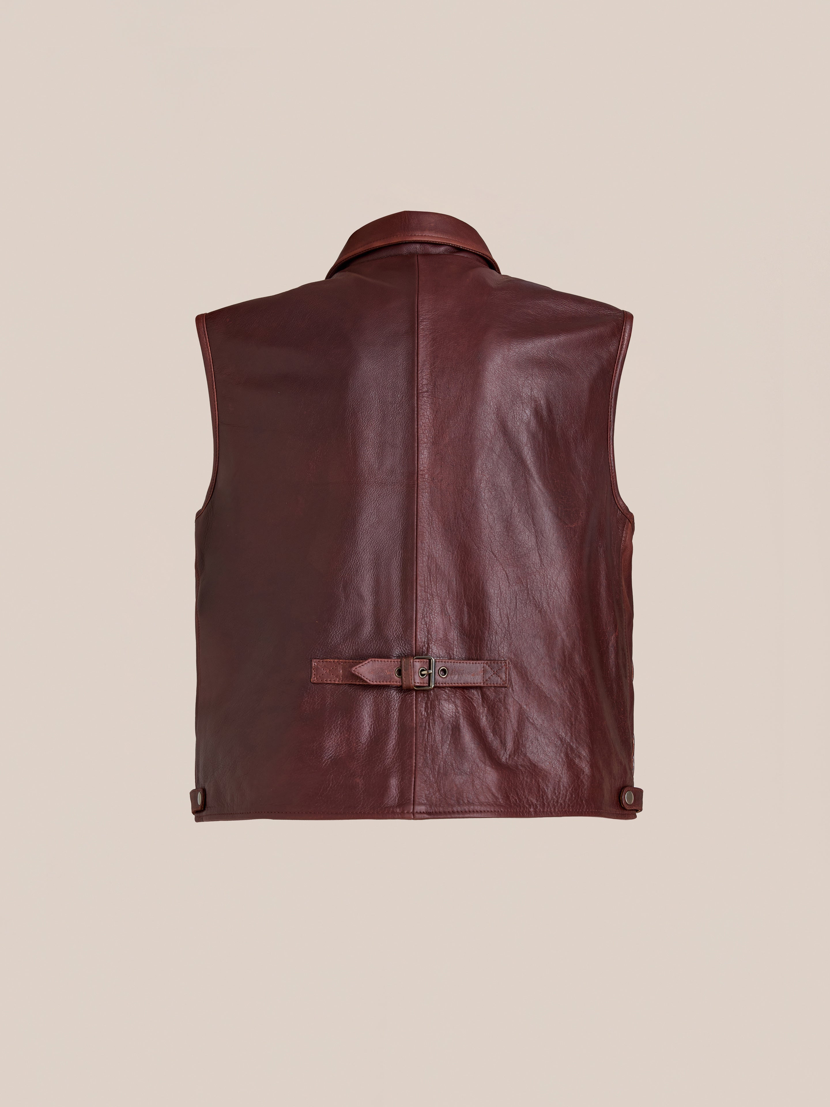 Back view of the Found Leather Pocket Vest: a sleeveless, distressed brown leather vest with a collar, utility pockets, and an adjustable waist strap.