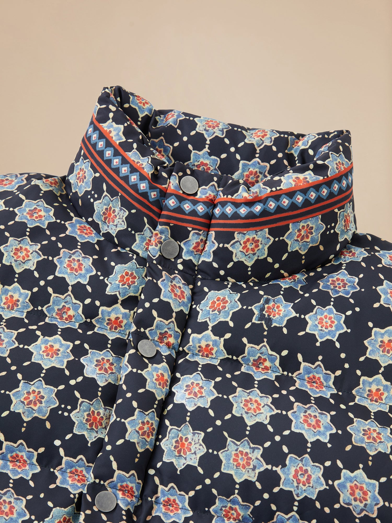 A collar with an Ajrak Block Puffer Jacket from Found brand, featuring a Pakistani block-printed floral pattern.