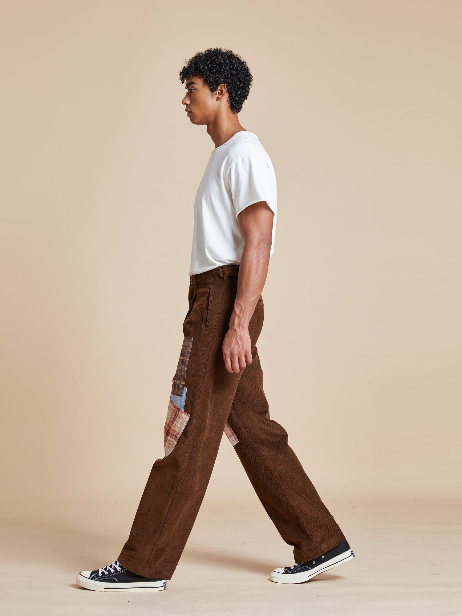 A man wearing Multi-Plaid Patch Corduroy pants by Found brand.