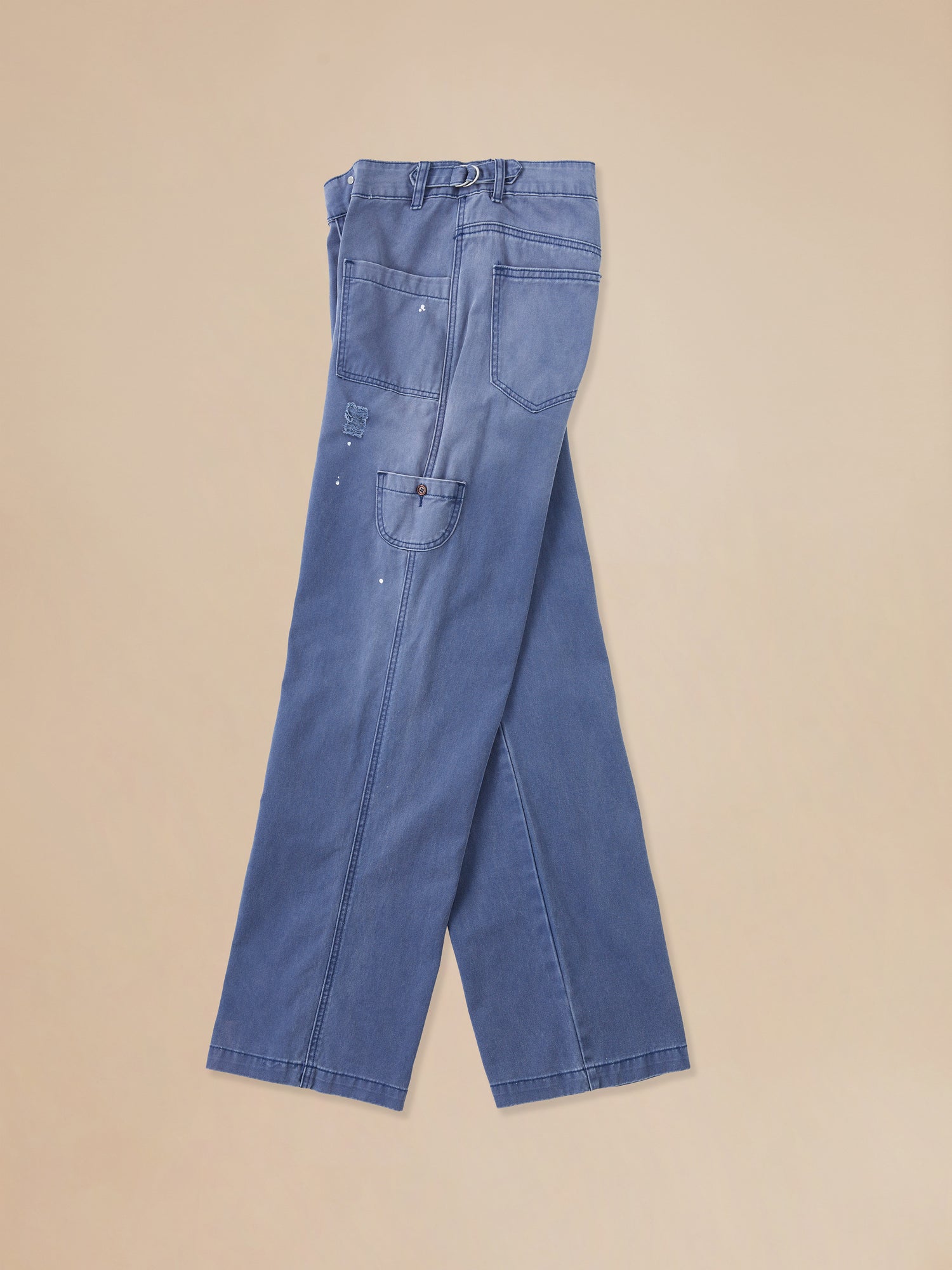 A pair of River Painters Chore Pants by Found on a beige background.