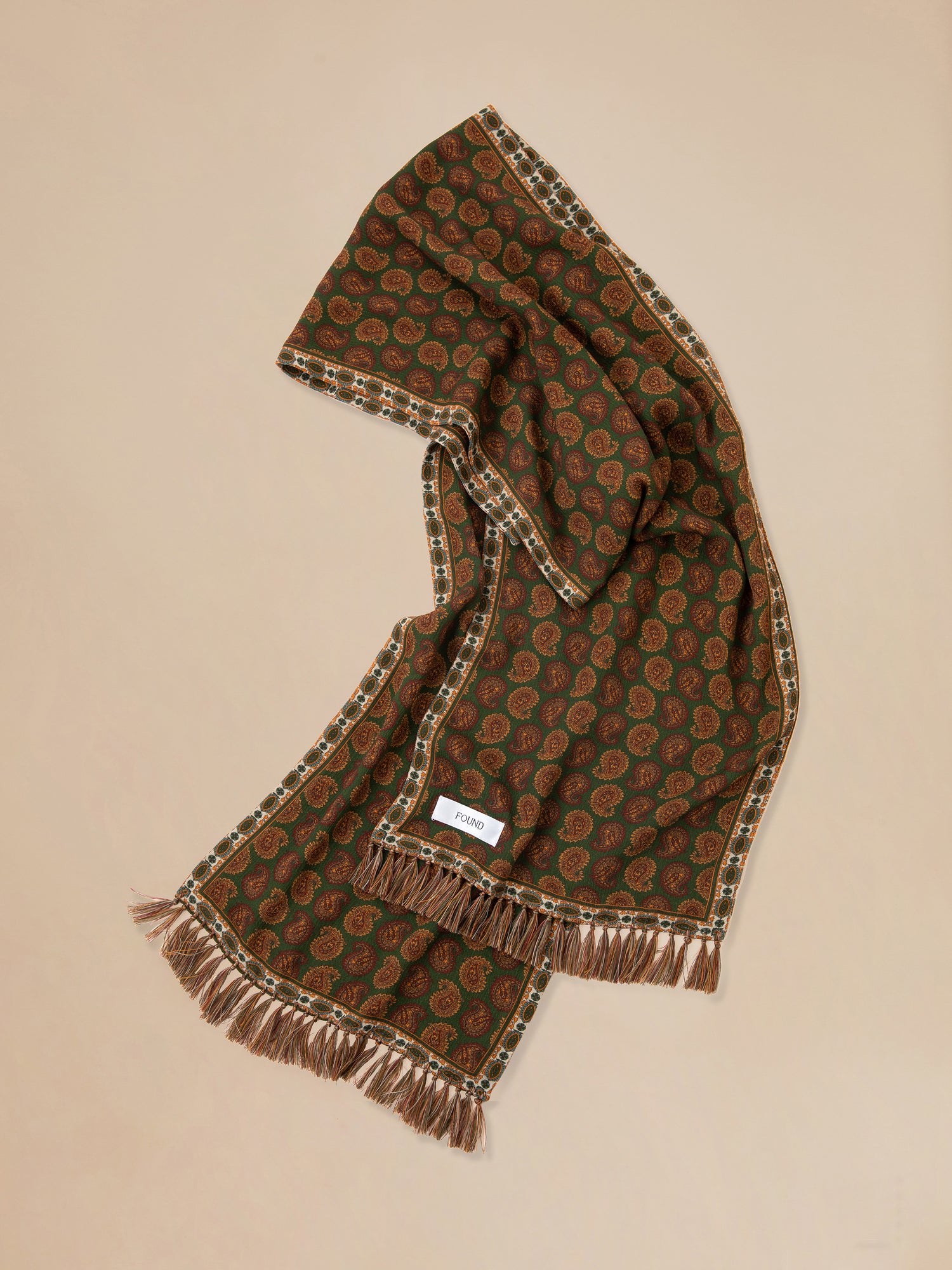 A hand-tied Paisley Forest Scarf with a paisley pattern by Found.