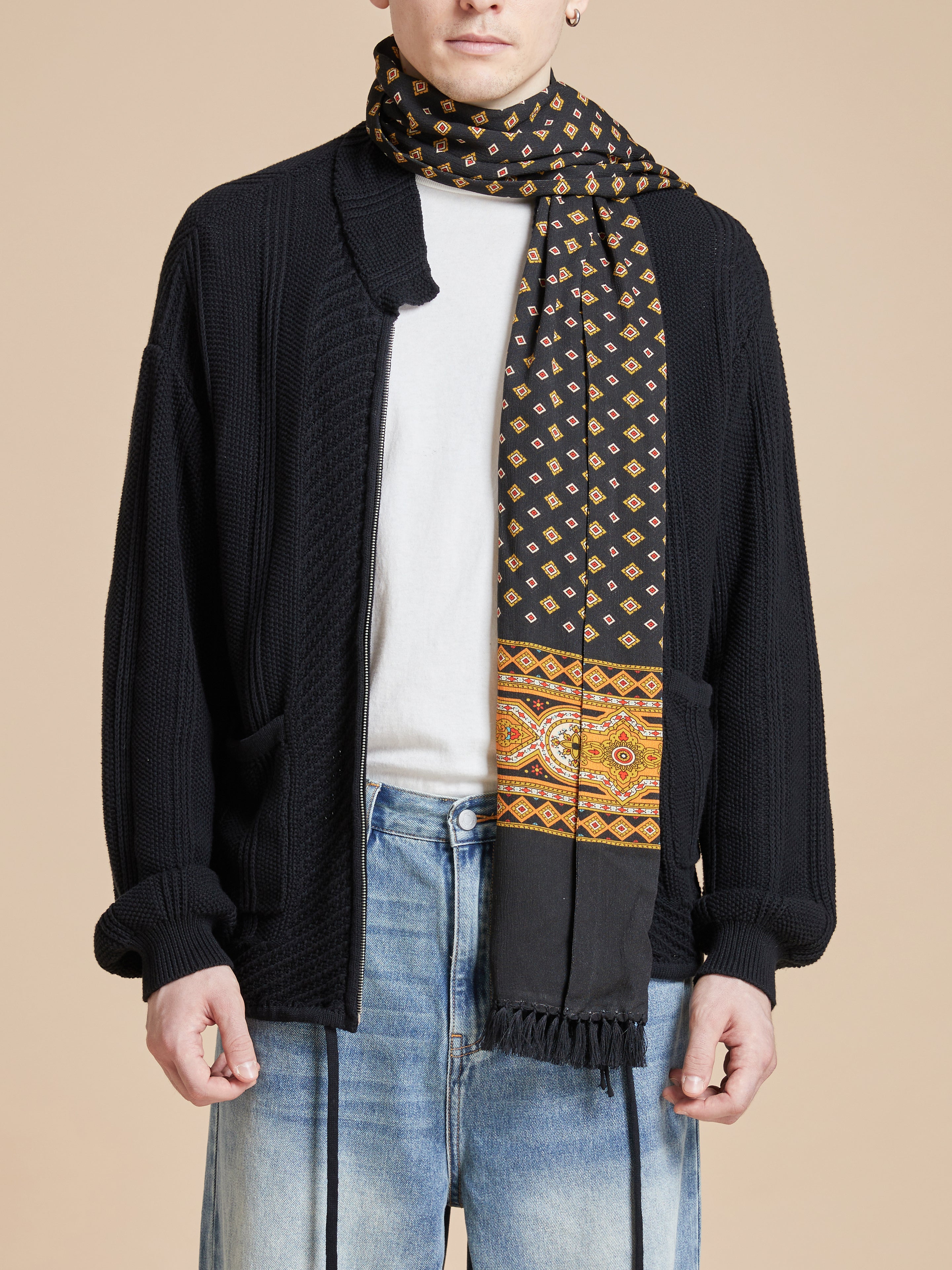 A man wearing a Found Pastures Print Scarf with hand-tied tassels.