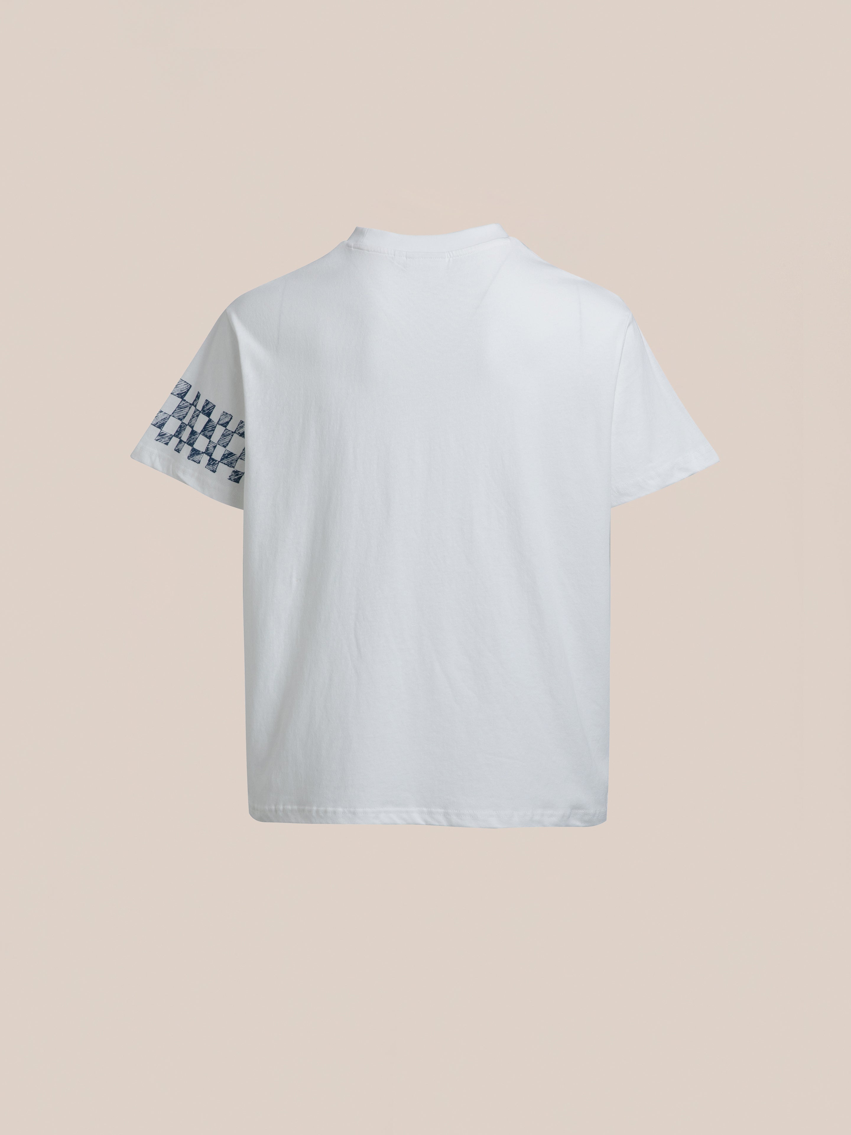 The Pen Flower Medley by FOUND, a white T-shirt featuring a small checkered pattern on the left sleeve, is displayed from the back against a beige background.