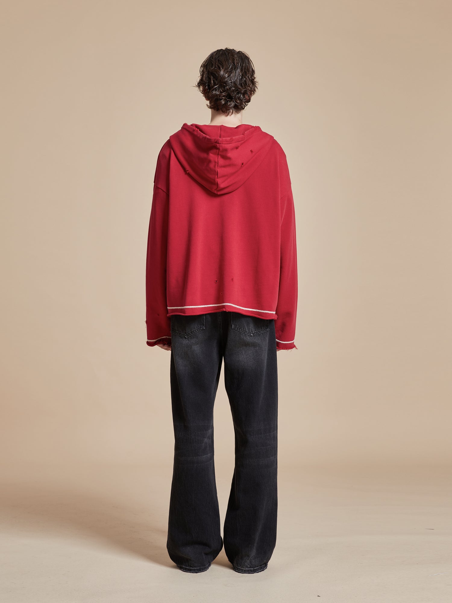 The back of a man wearing a Found Phulkari Embroidered Hoodie and black pants.