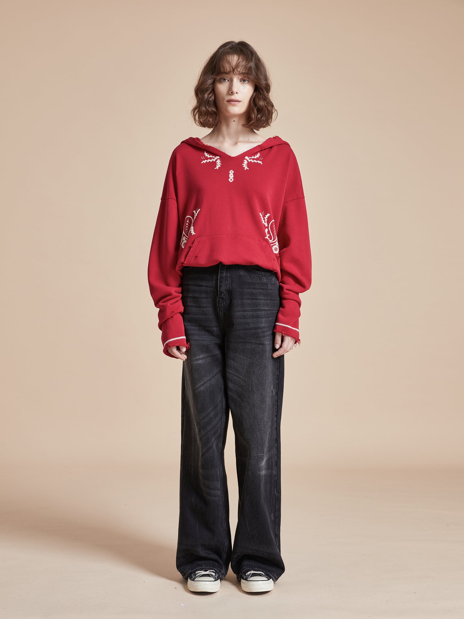 A model wearing a Found Phulkari Embroidered Hoodie and black wide leg pants.