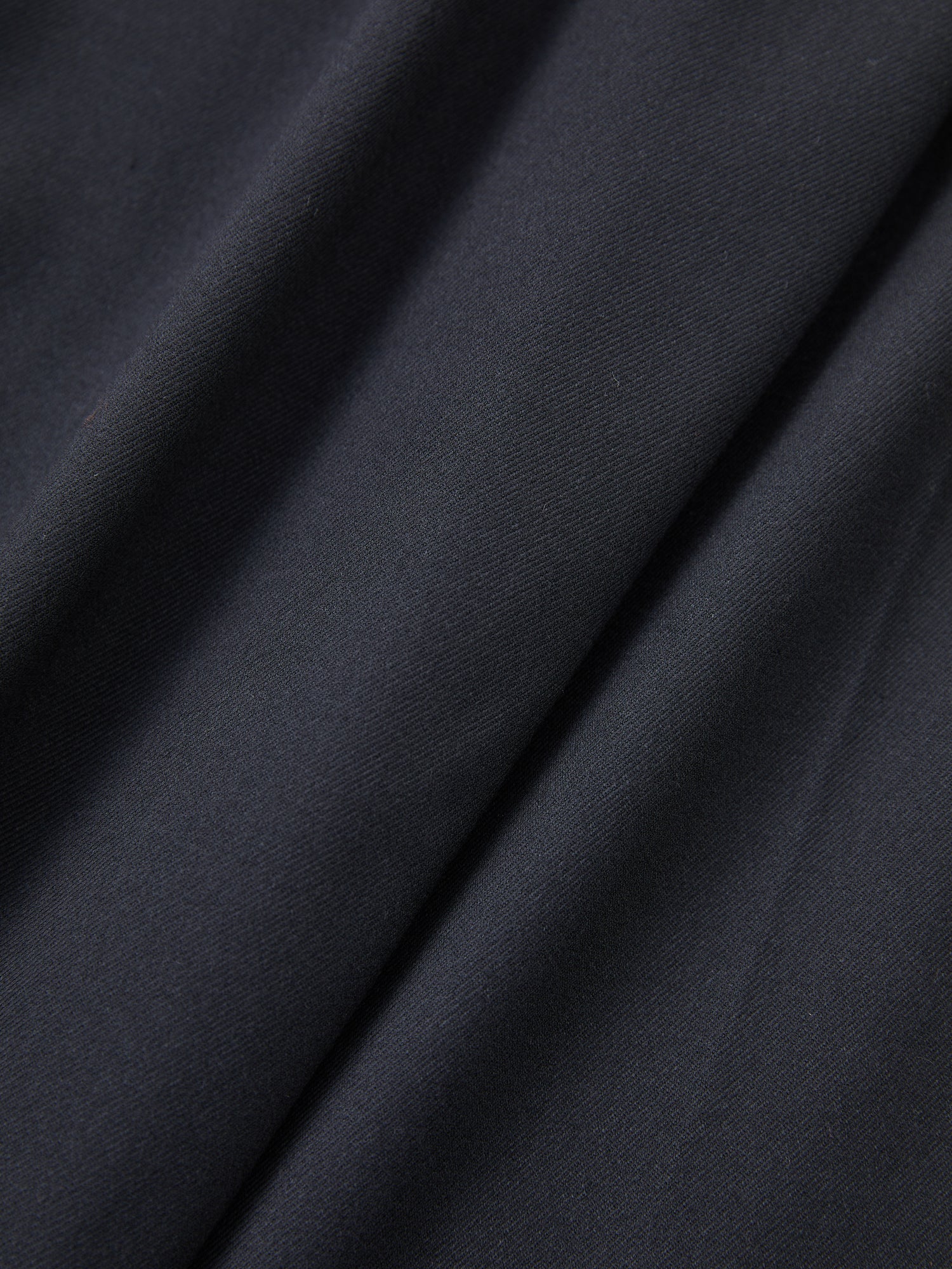 A close up image of Found Pleated Trousers made of black fabric.