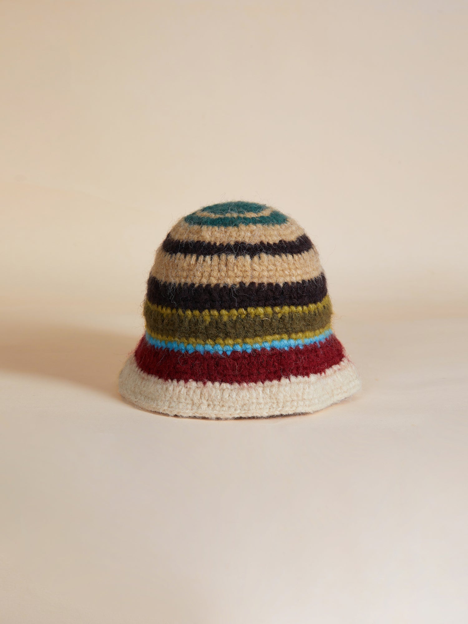 A Found Stripe Knit Beanie bucket hat on a beige surface.