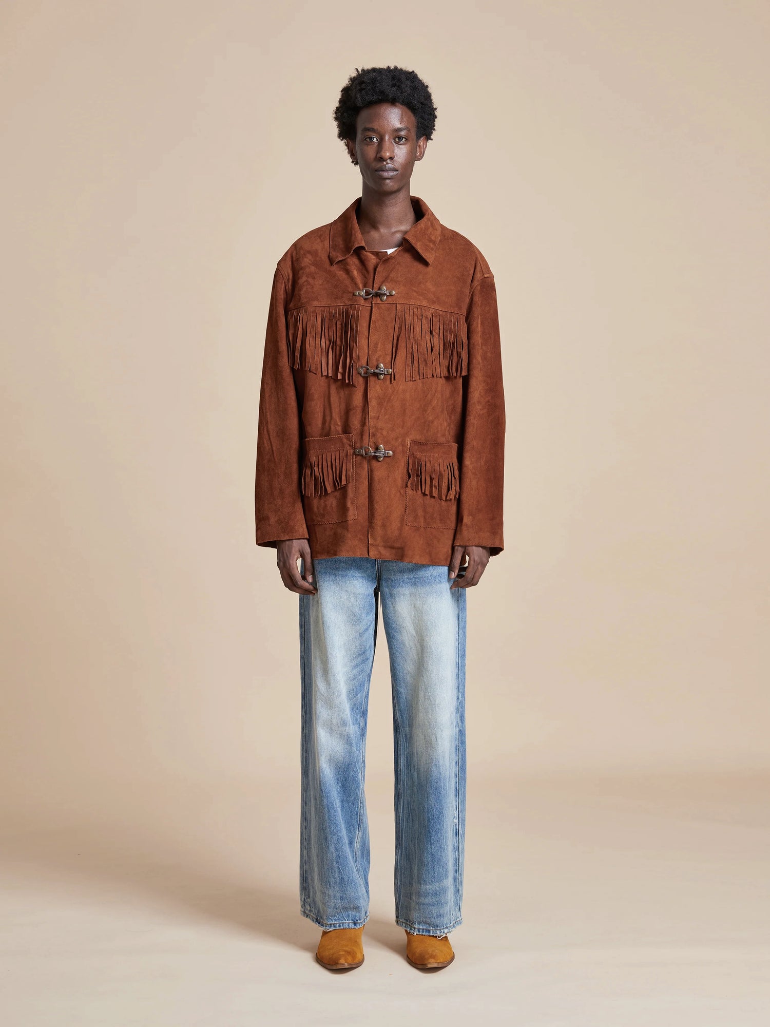 A man wearing a Found Tobacco Fringe Suede Buckle Jacket.