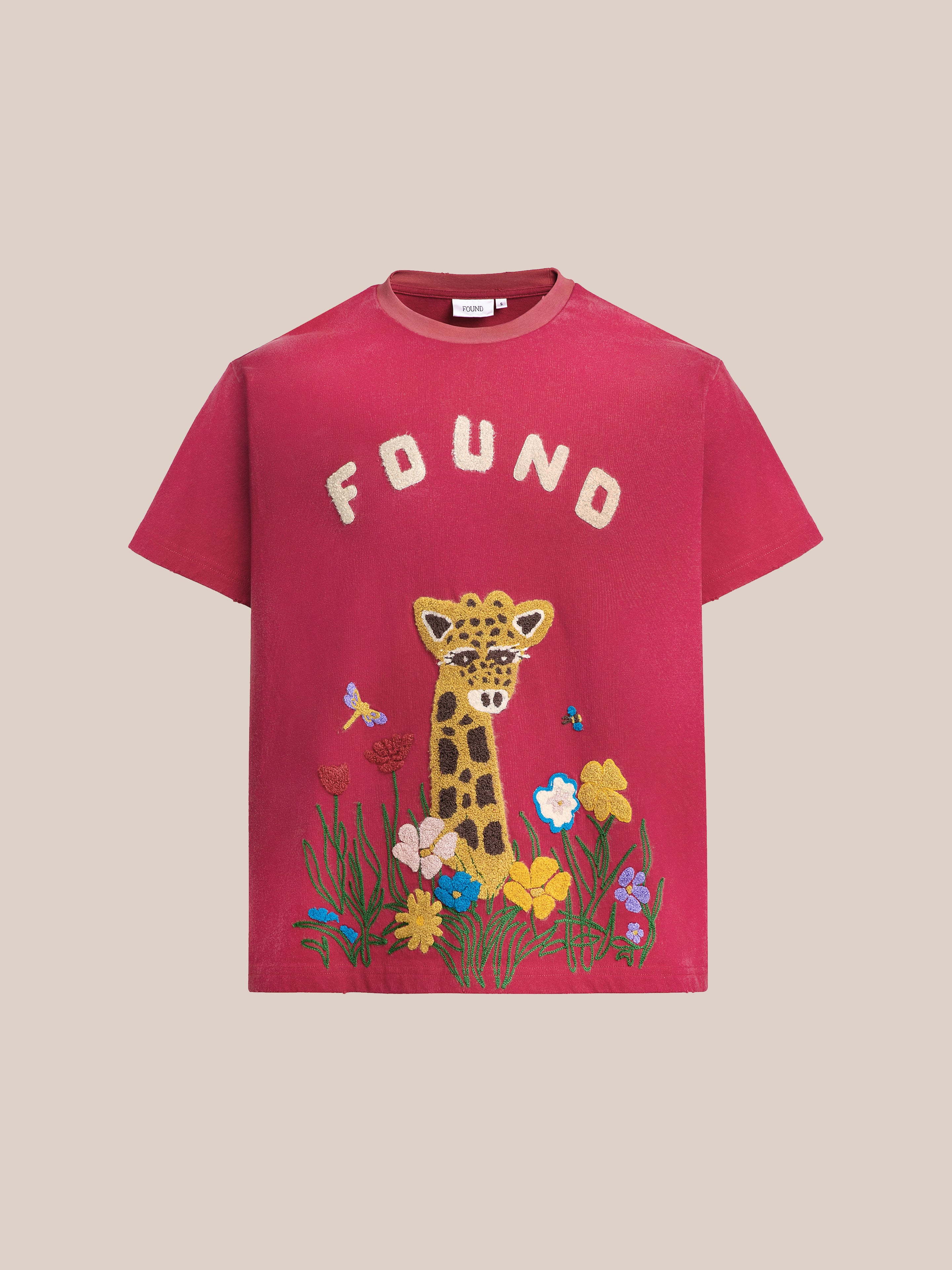 The FOUND Embroidered Wildlife Tee features a charming giraffe with colorful flowers and butterflies, all on soft French-terry cotton for comfort.