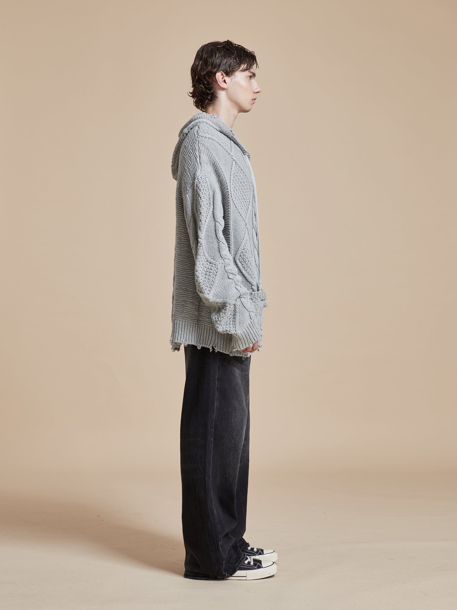 A man in a cozy Found Zip Up Distressed Cable Knit Hoodie.