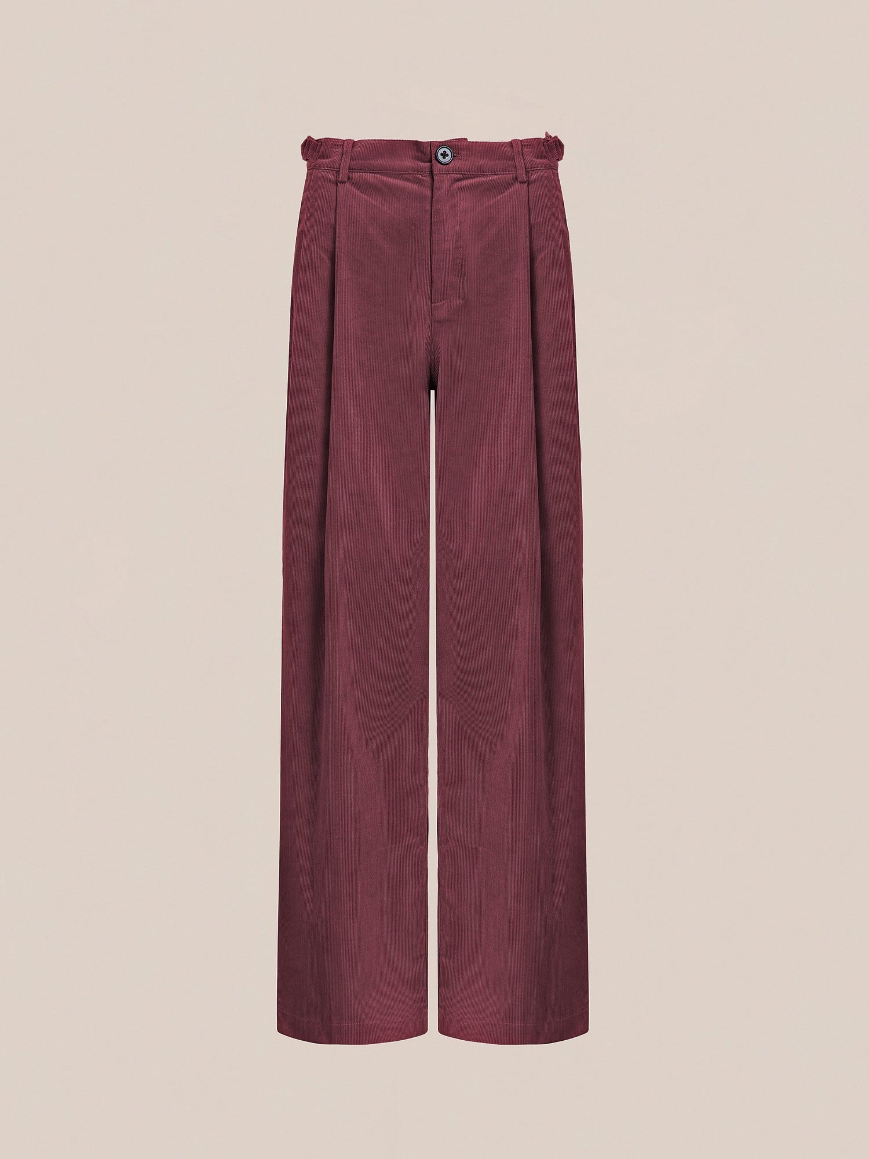 The Corduroy Pleated Trousers by FOUND are designed in red with a high-waisted, double-pleated wide-leg style, featuring a button and zip closure on a plain background.