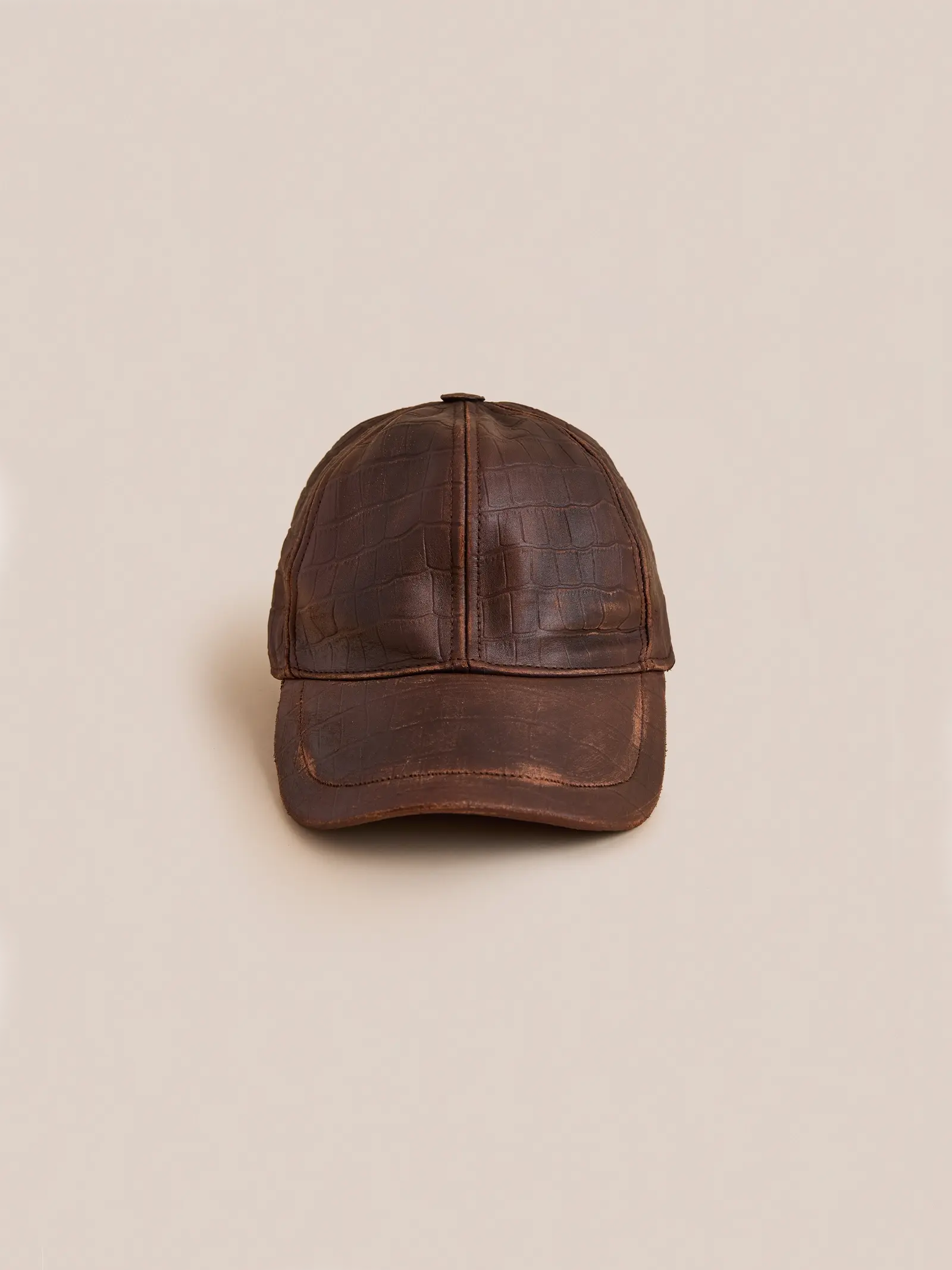 The Found Croc Embossed Distressed Leather Cap—brown leather with a crocodile texture and adjustable fit—is shown on a plain beige background.