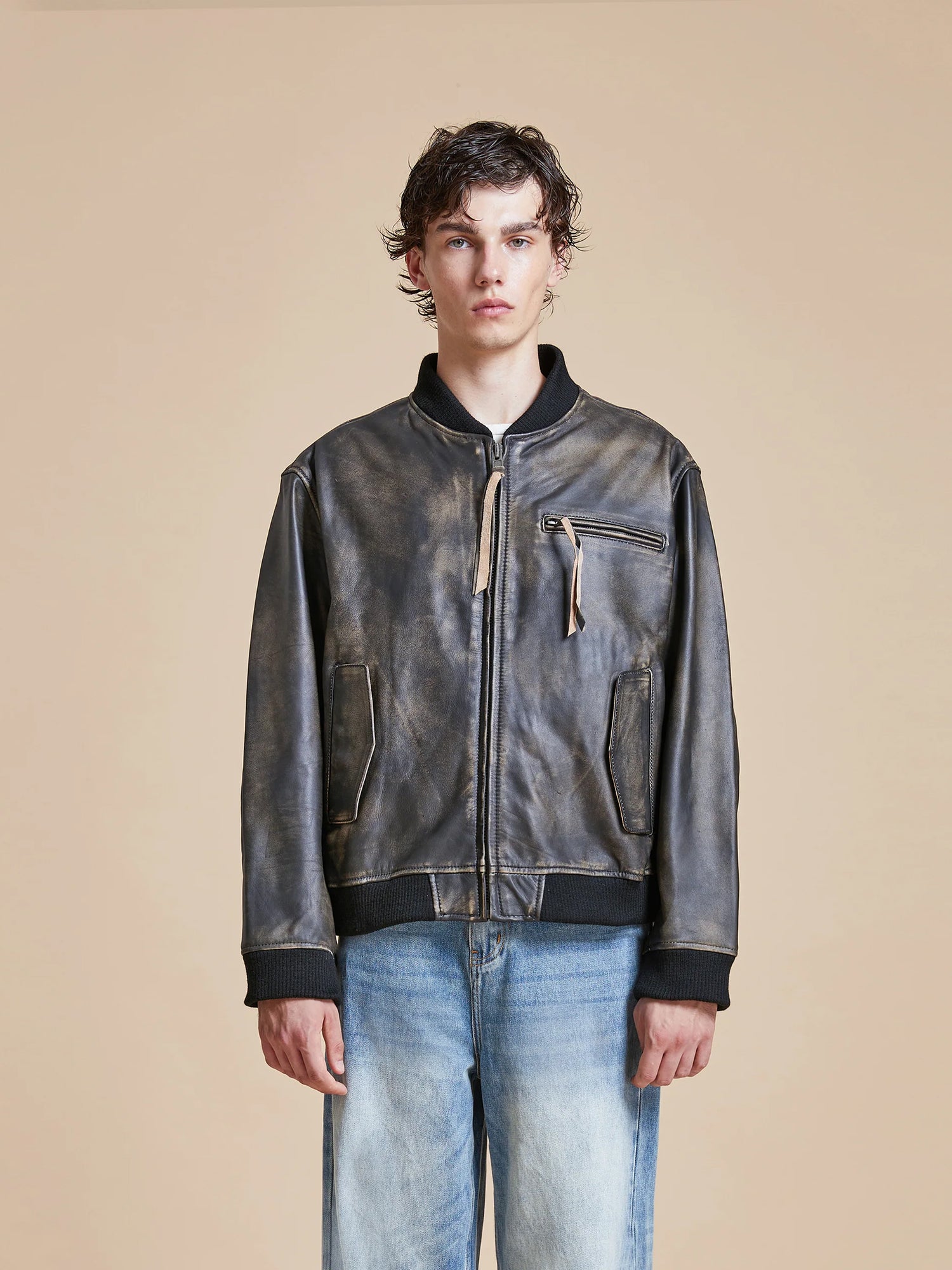 A man donning a Found Distressed Pavement Leather Bomber Jacket.
