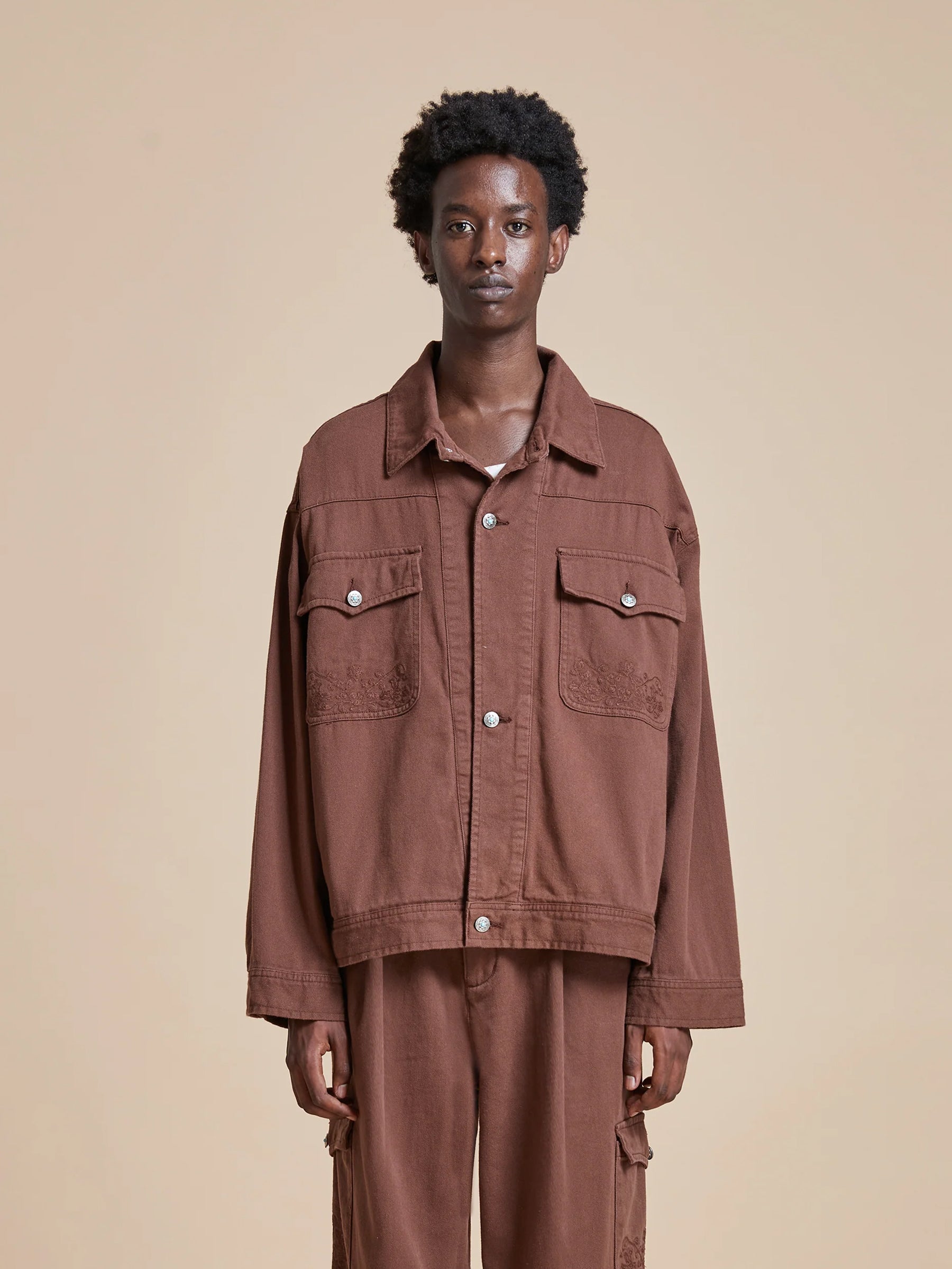 A man sporting a classic silhouette with an antique blue stone buttoned Found Dusky Western Trucker Jacket.
