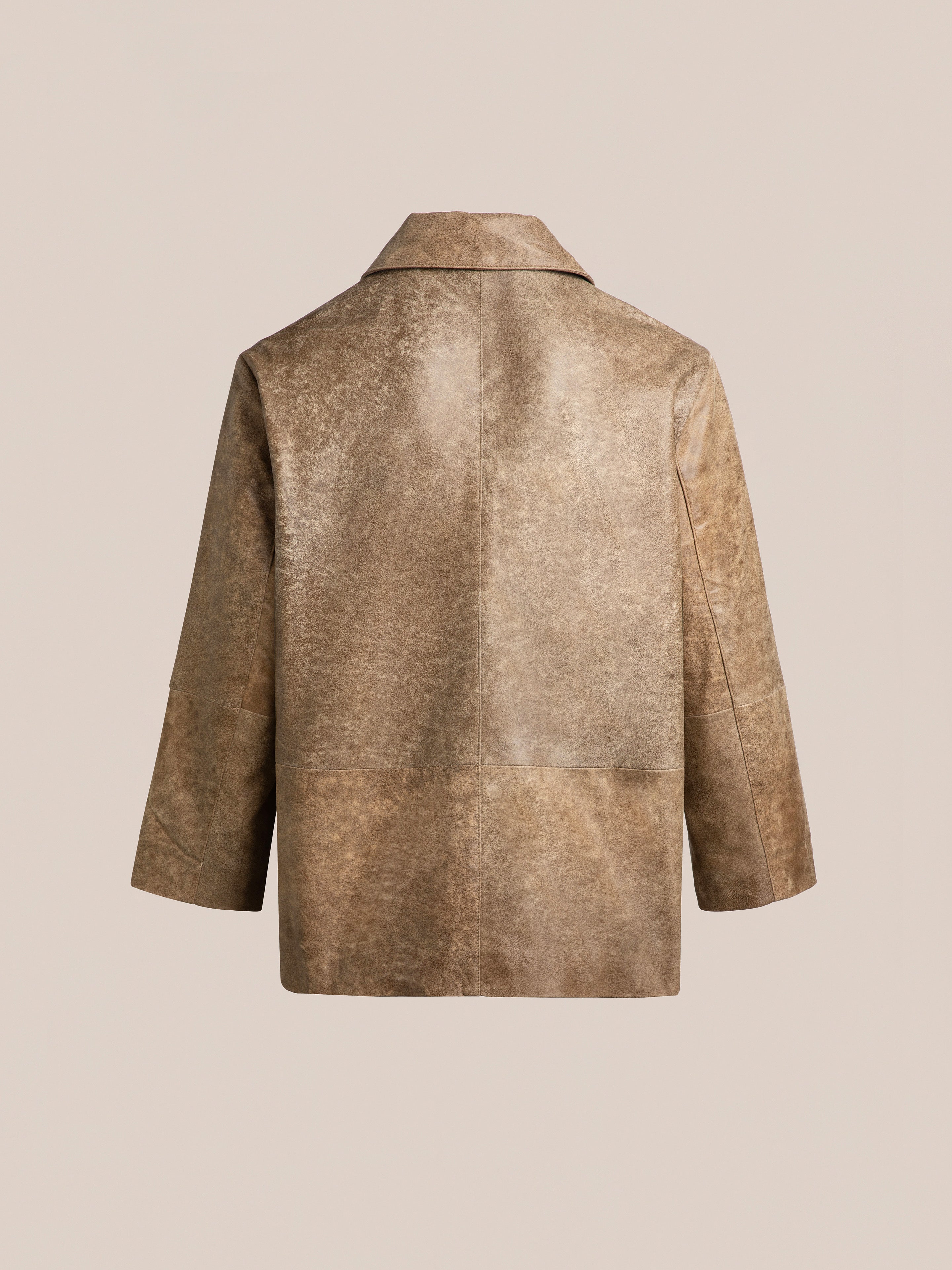 The Fawn Double Breasted Leather Jacket from FOUND features a vintage-inspired brown leather with hand-distressed texture, classic collar, and straight sleeves, shown from the back on a plain beige background.