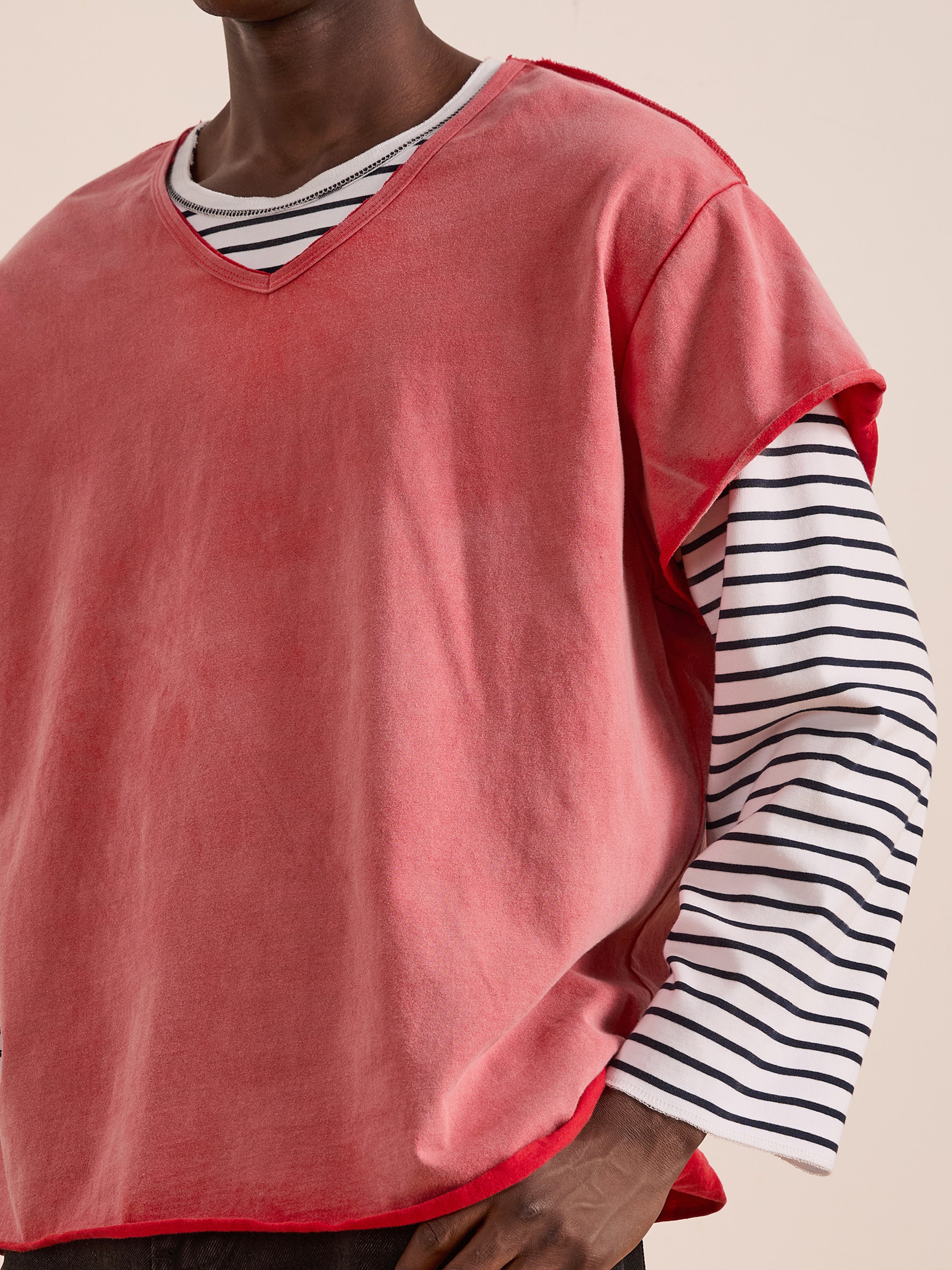 A person wears the FOUND Double Layer LS Tee—a loose, sleeveless red top layered over a black striped long-sleeve with a sunfade wash. Only the upper body is visible.