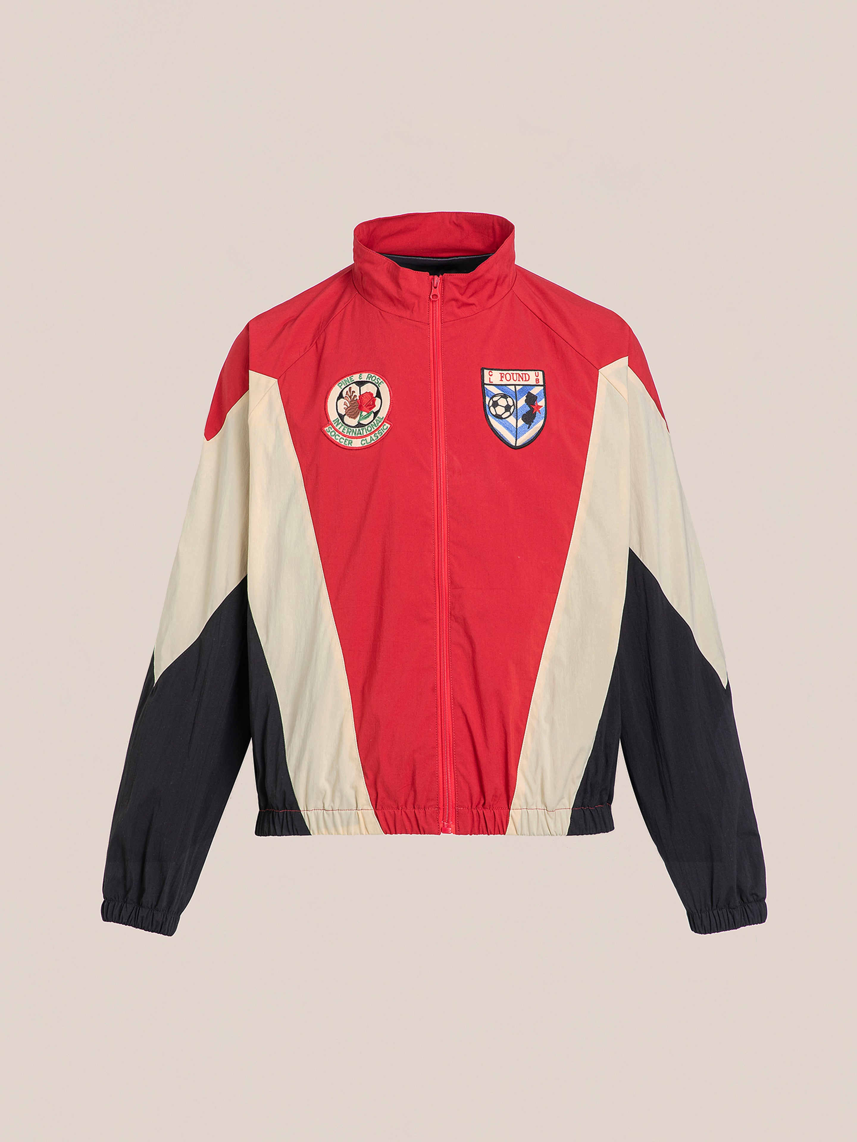 The FOUND Pine and Rose Track Jacket combines style and functionality with its unisex design in red, white, and black. Featuring elastic cuffs and hem, it includes two striking chest patches that embody sporty elegance.