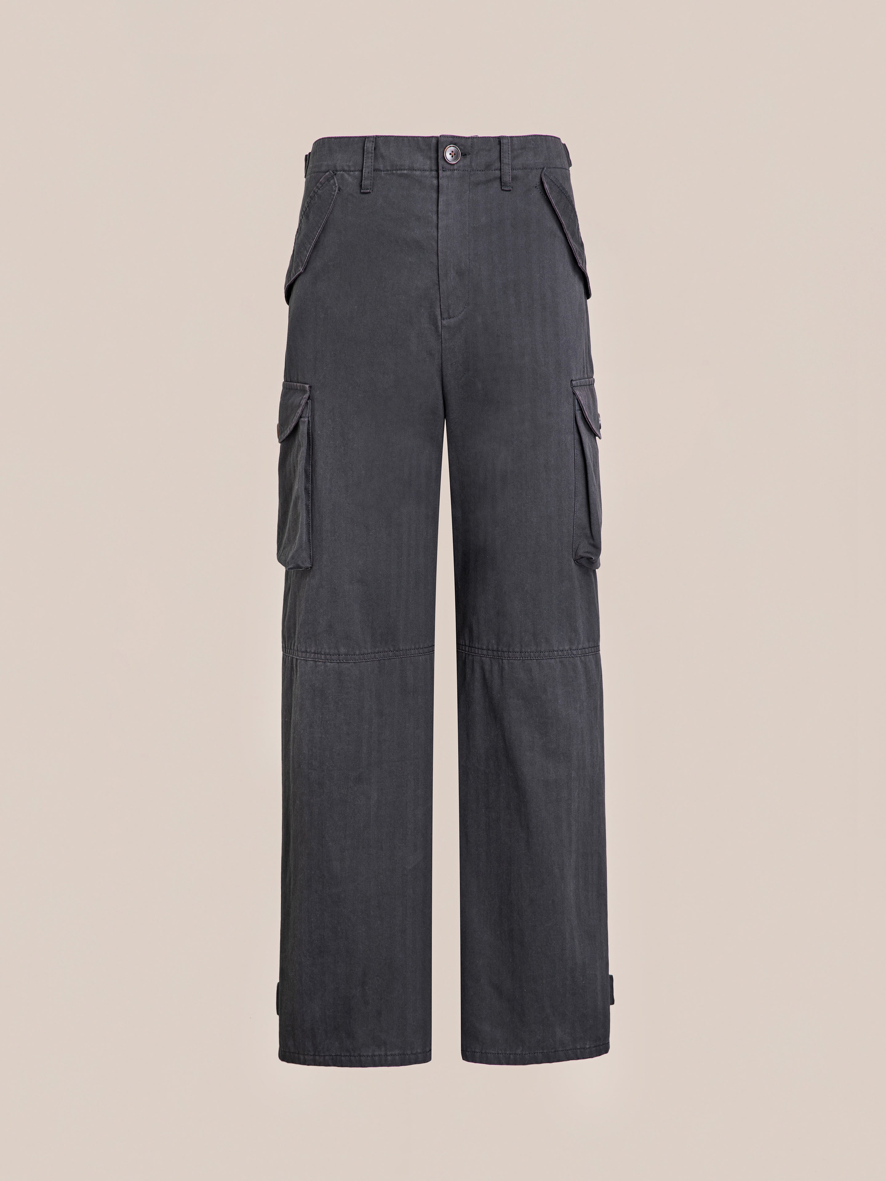 A pair of Utility Herringbone Cargo Pants by FOUND, with six roomy pockets and a unisex relaxed fit, is displayed against a plain beige background.