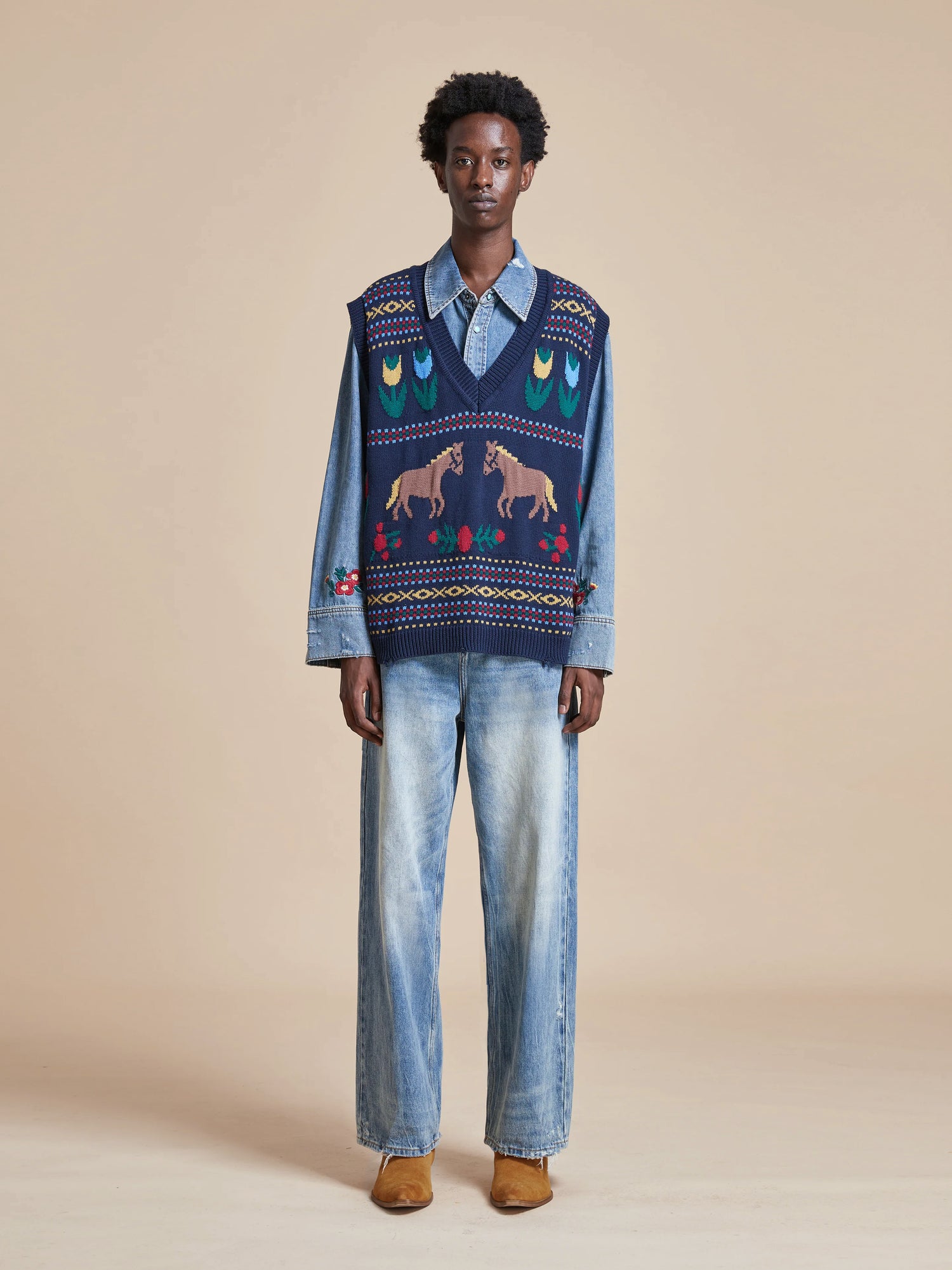 A man wearing a Found Isle Horse Reverie Sweater Knit Vest decorated with hand-distressed ribbing.
