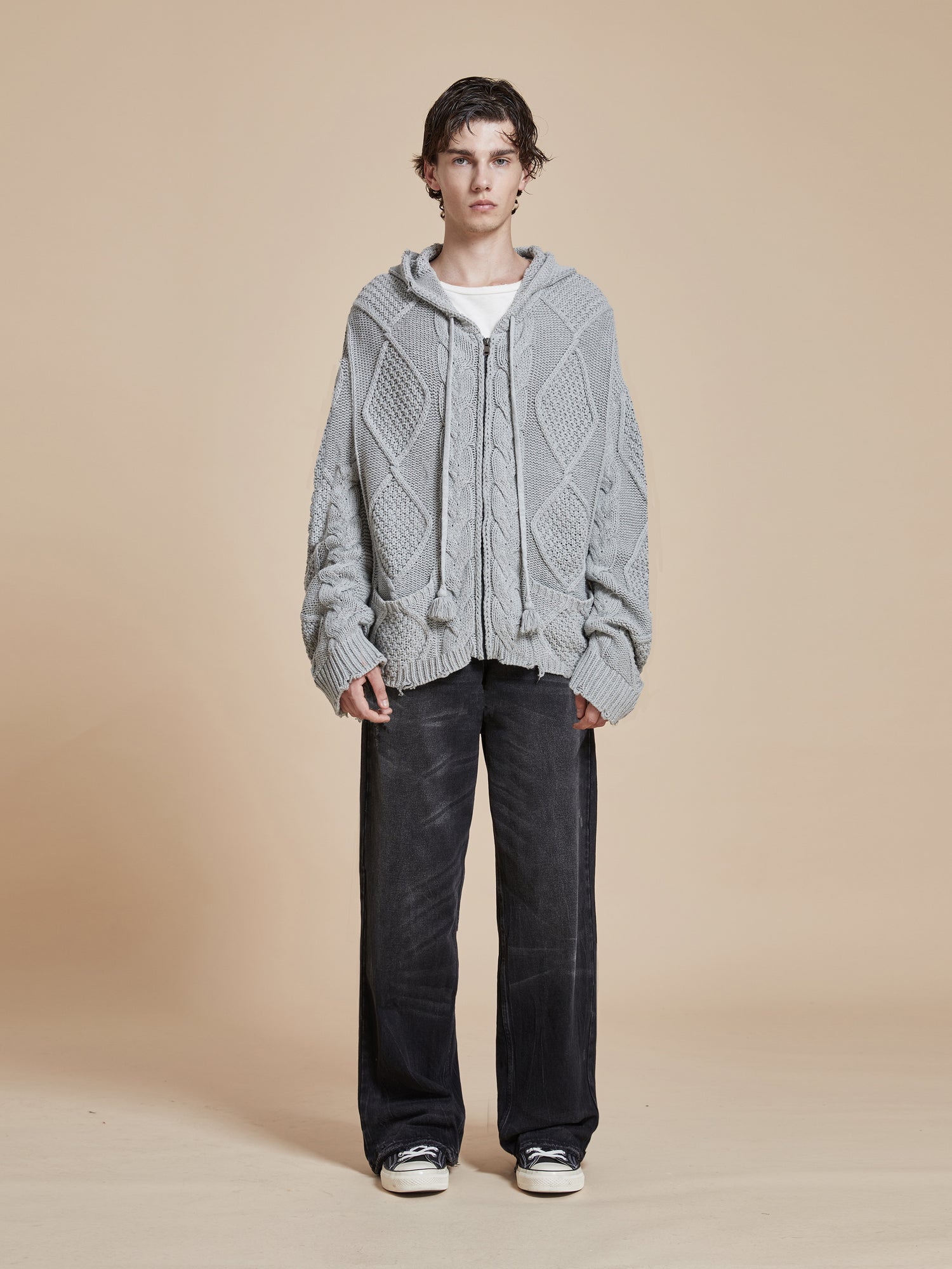 The model is wearing a Found Zip Up Distressed Cable Knit Hoodie.