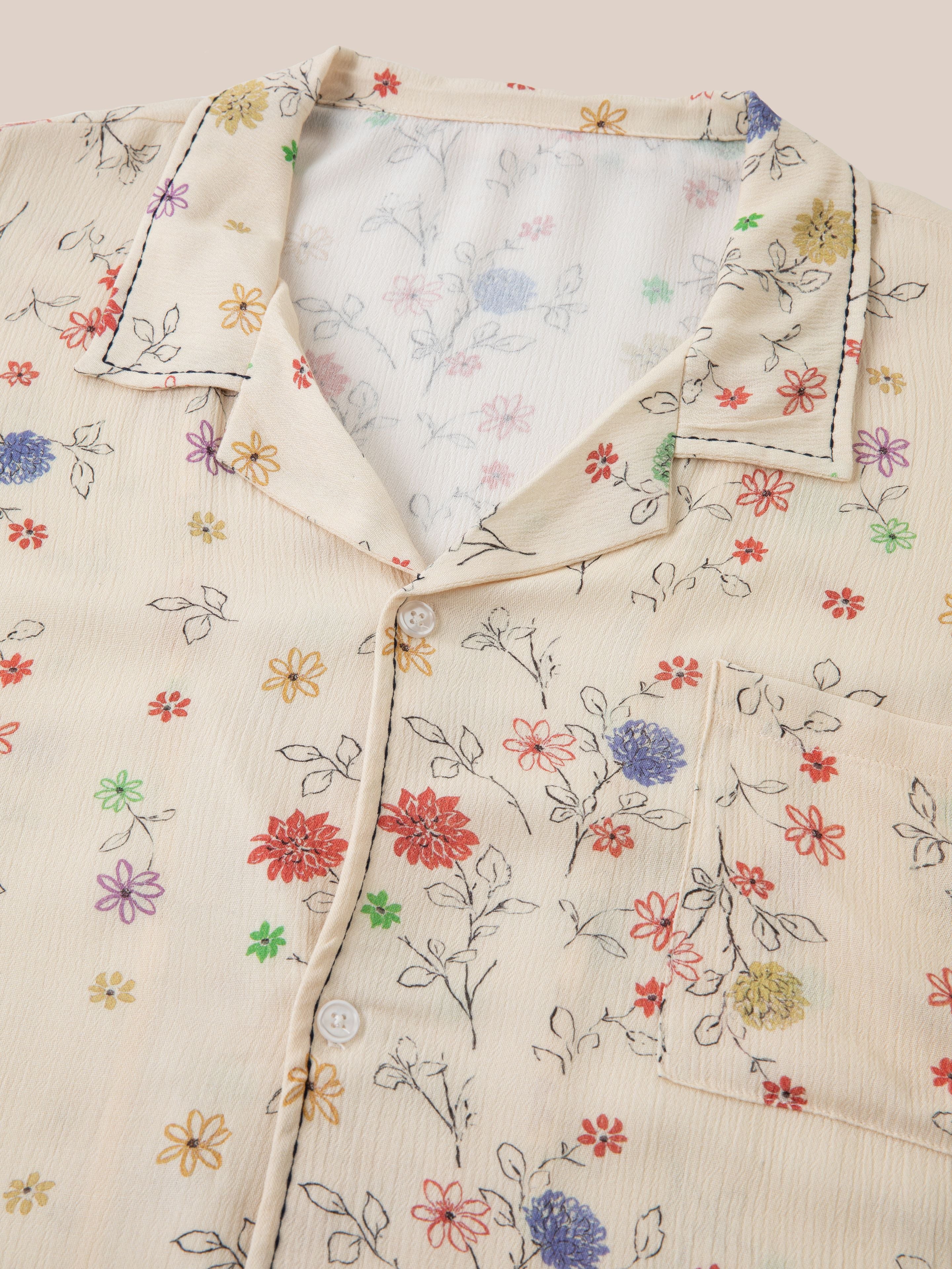 Lightweight rayon fabric button-down shirt with a multi-colored floral print, featuring a collar, a chest pocket, and black stitch details. This Profound Multi Floral Camp Shirt combines style and comfort effortlessly.