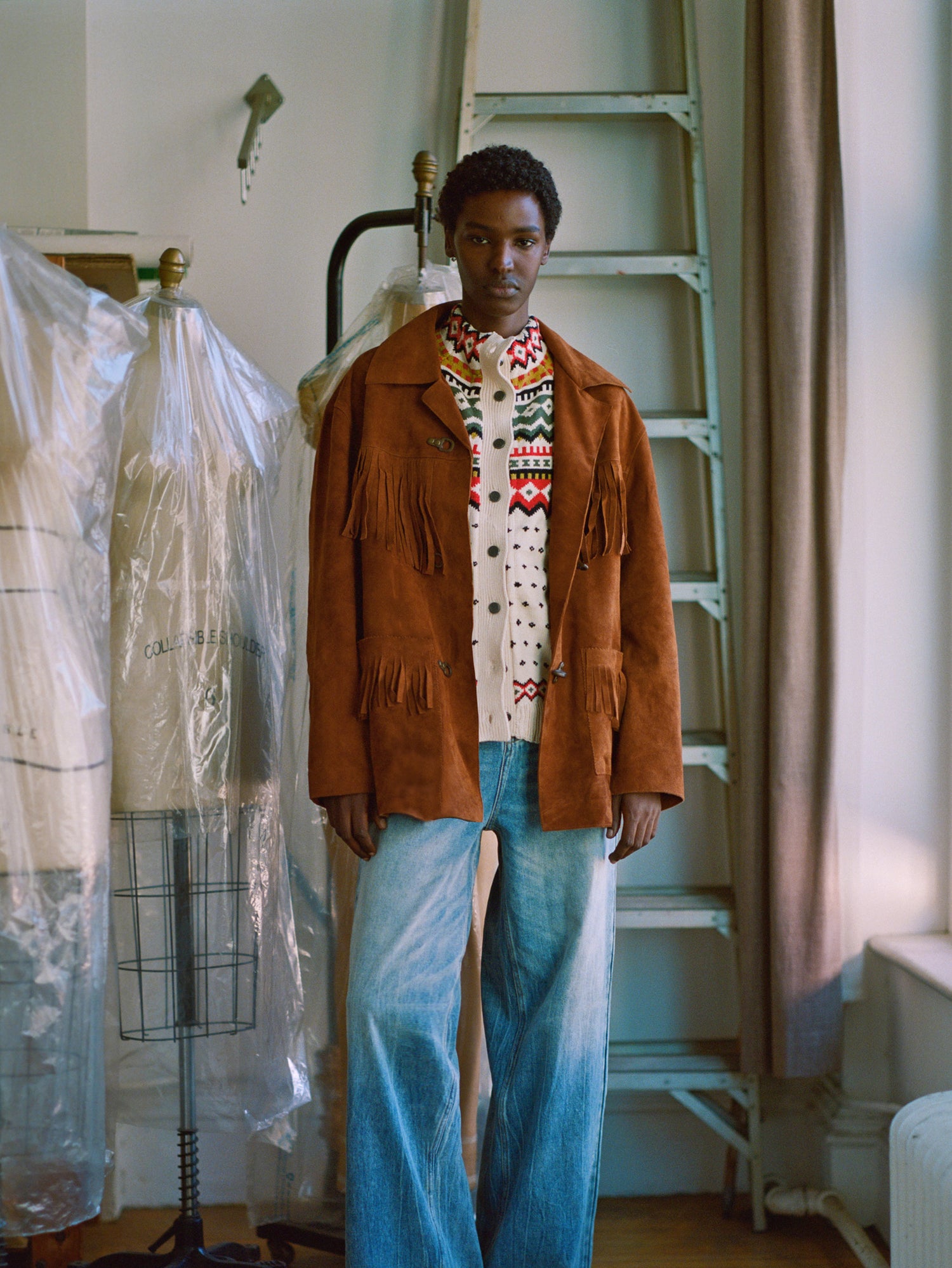 A man in a Found Tobacco Fringe Suede Buckle Jacket standing in a room.