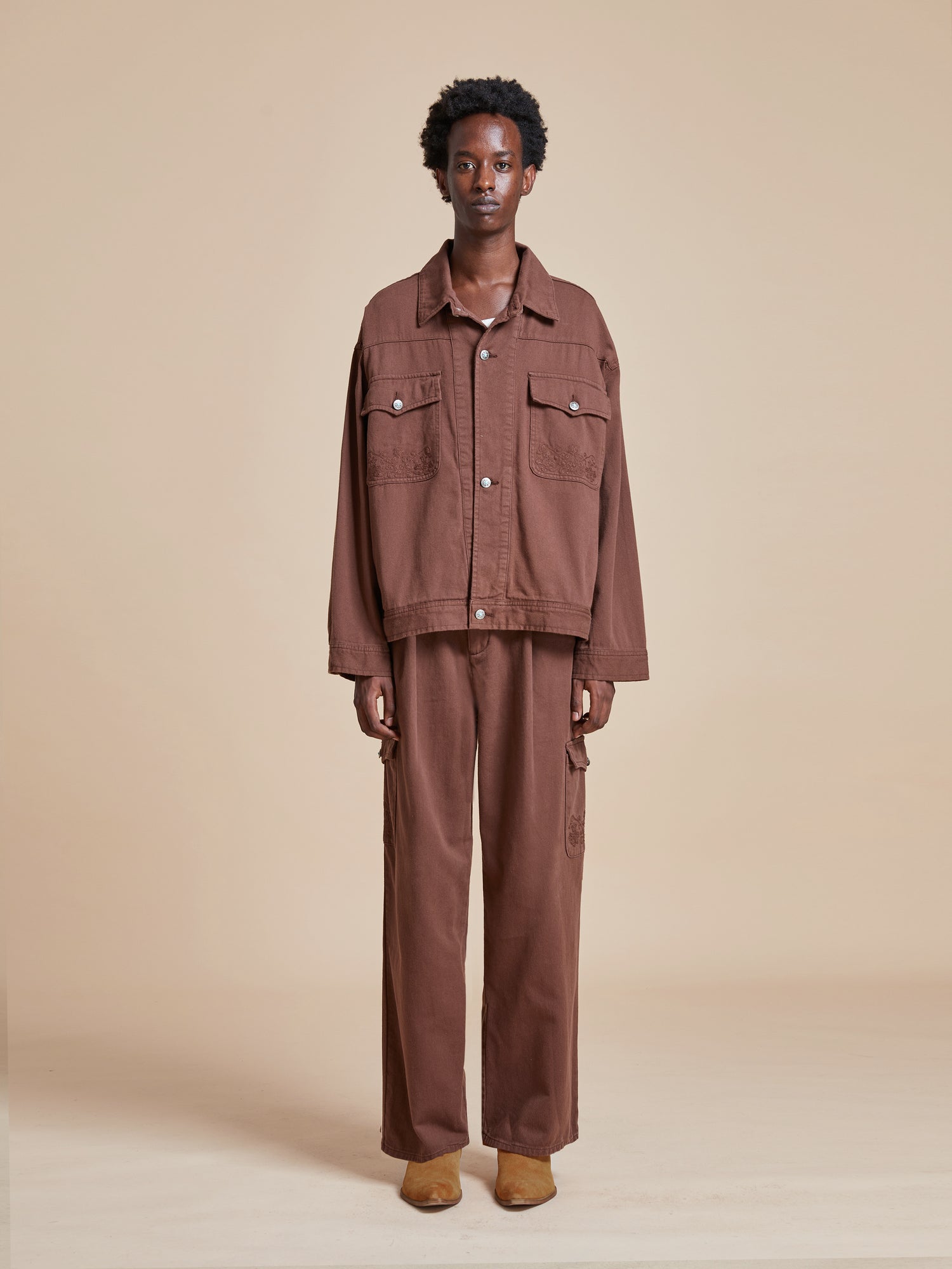 The model is wearing a Dusky Western Trucker Jacket and pants.