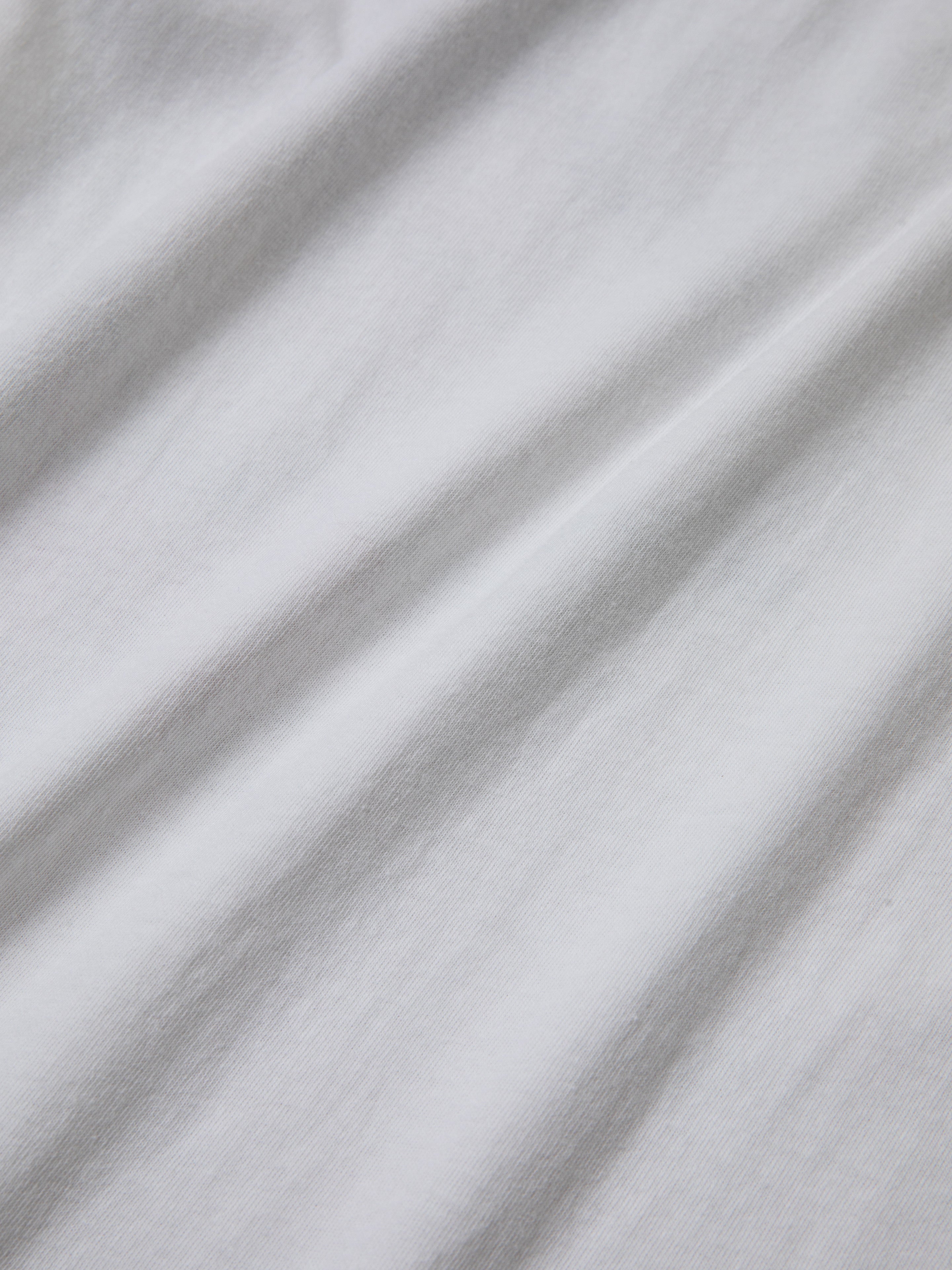 Close-up of white fabric with visible texture and soft folds, evoking a vintage feel reminiscent of the classic FOUND Rodeo Tee.