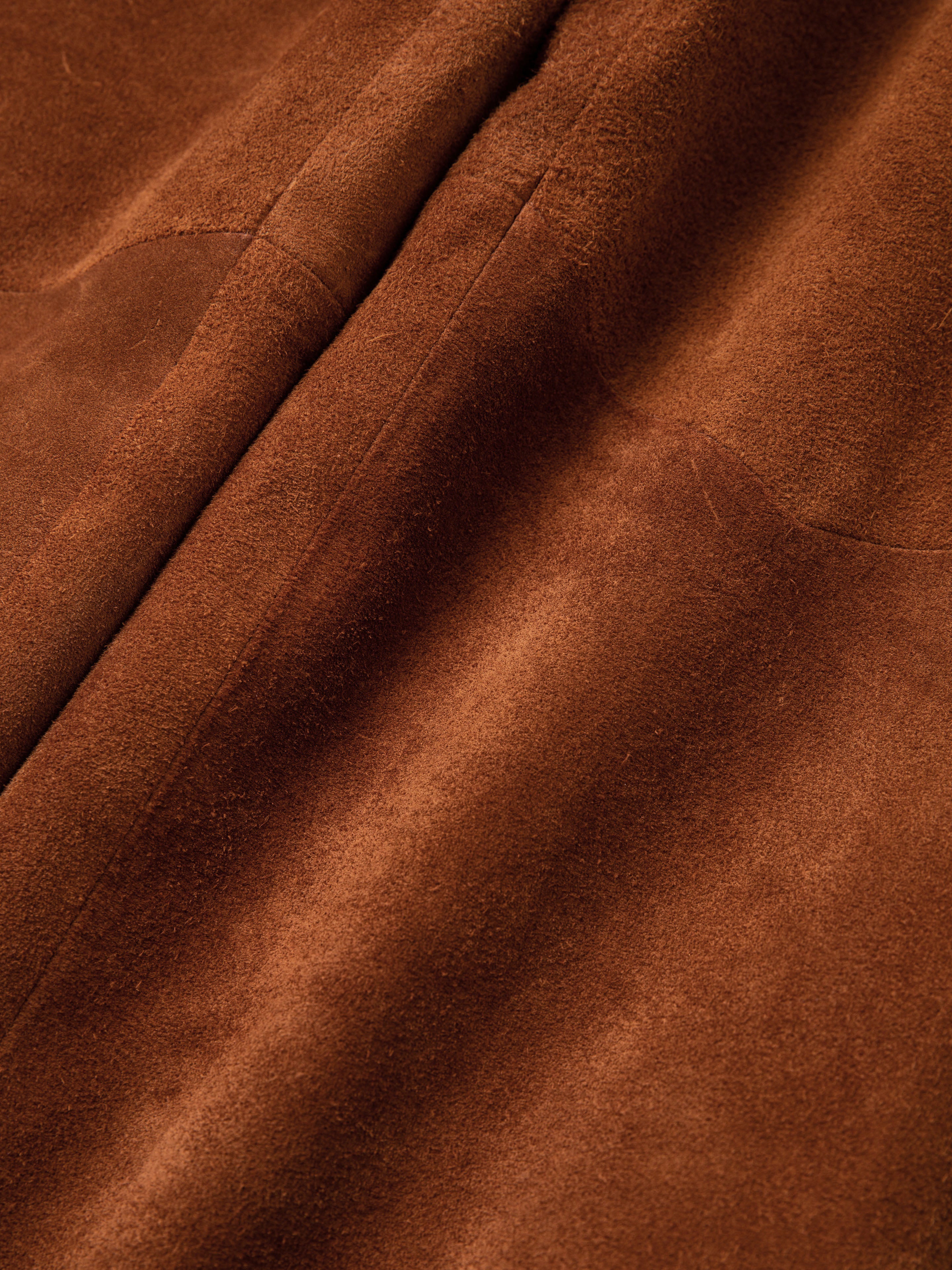 Close-up of a pair of FOUND Suede Moto Pants, highlighting their soft and textured brown suede surface.