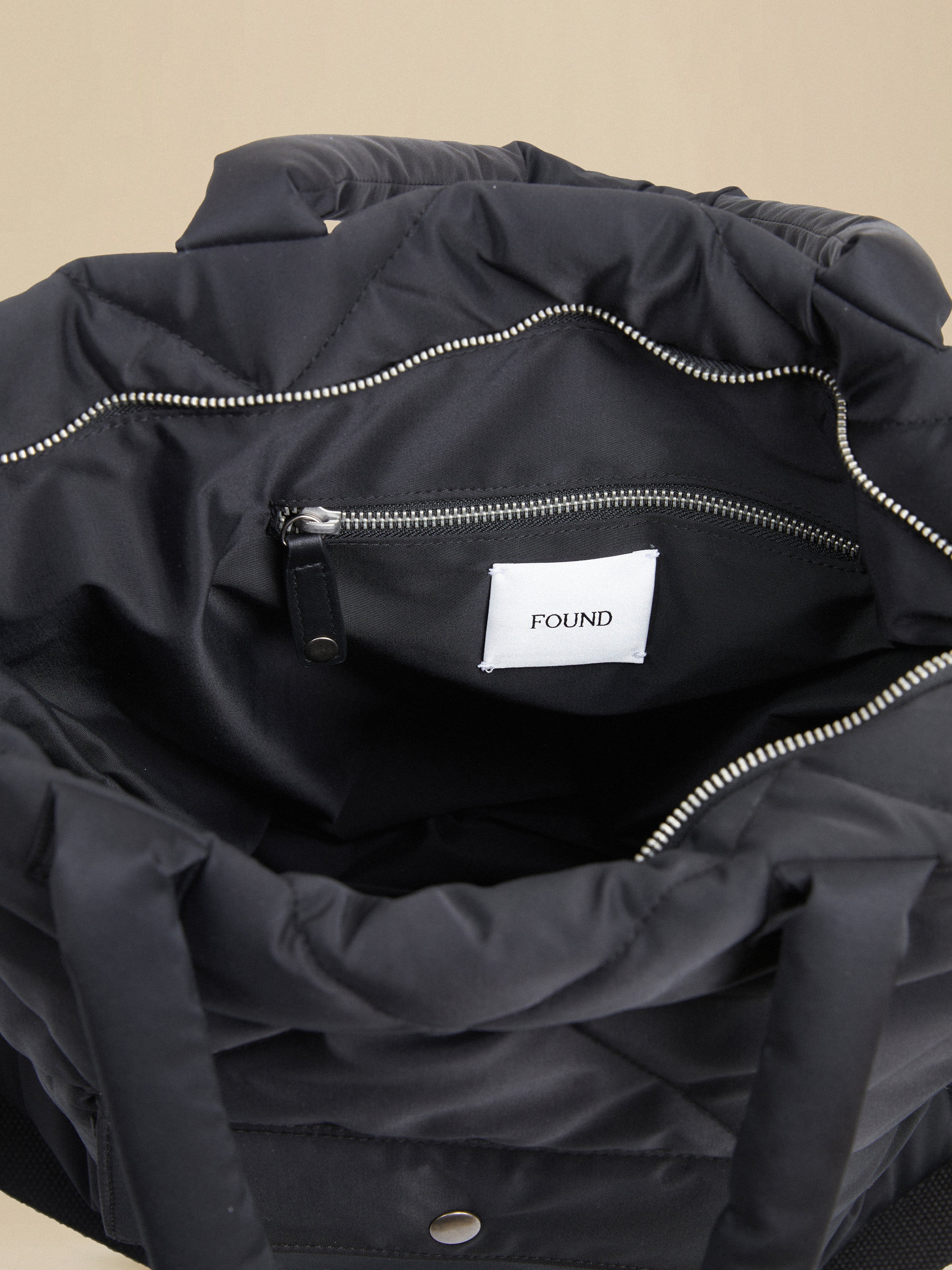 A black Dayer Nylon Quilted Bag tote bag with zippers and a spacious interior by Profound.