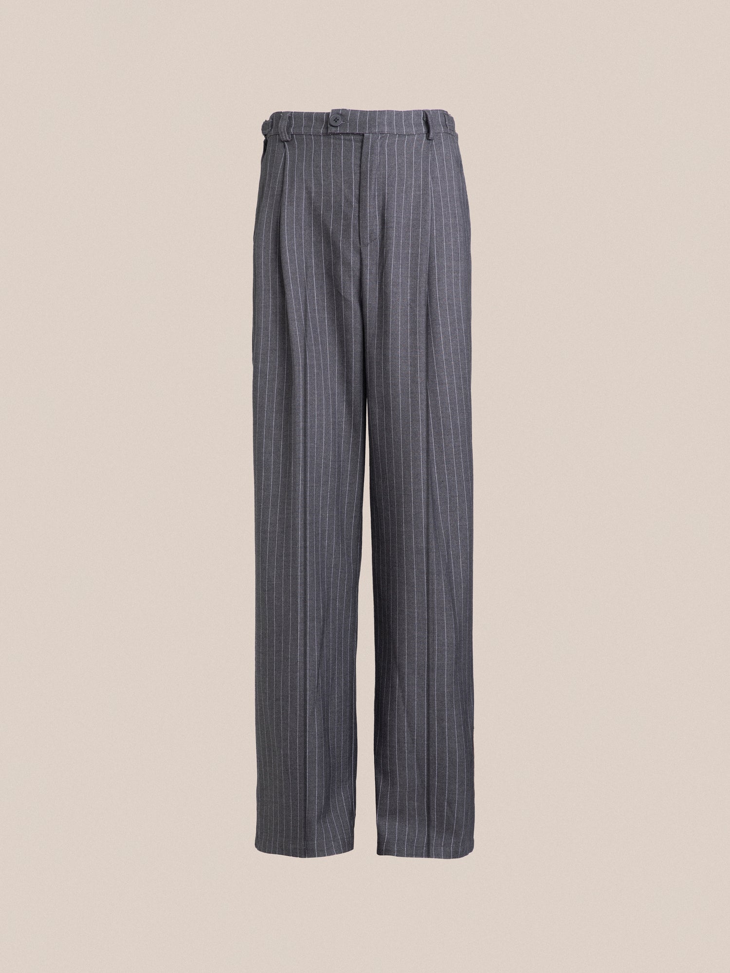 A double pleated, grey Pinstripe Pleated Trousers on a beige background by Found.