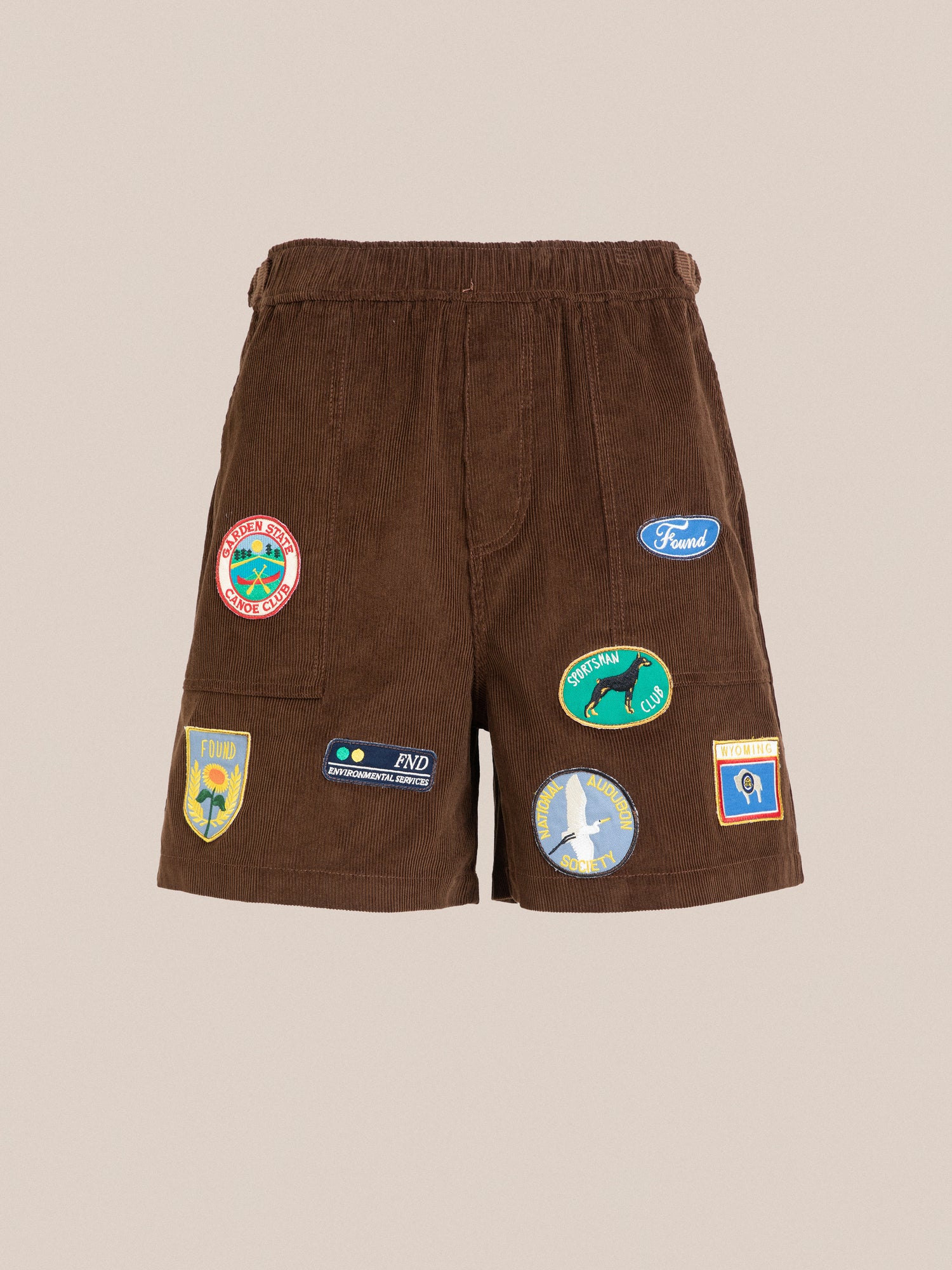 A brown Canoe Multi Patch Corduroy Shorts from Found with cricket sport patches on it.