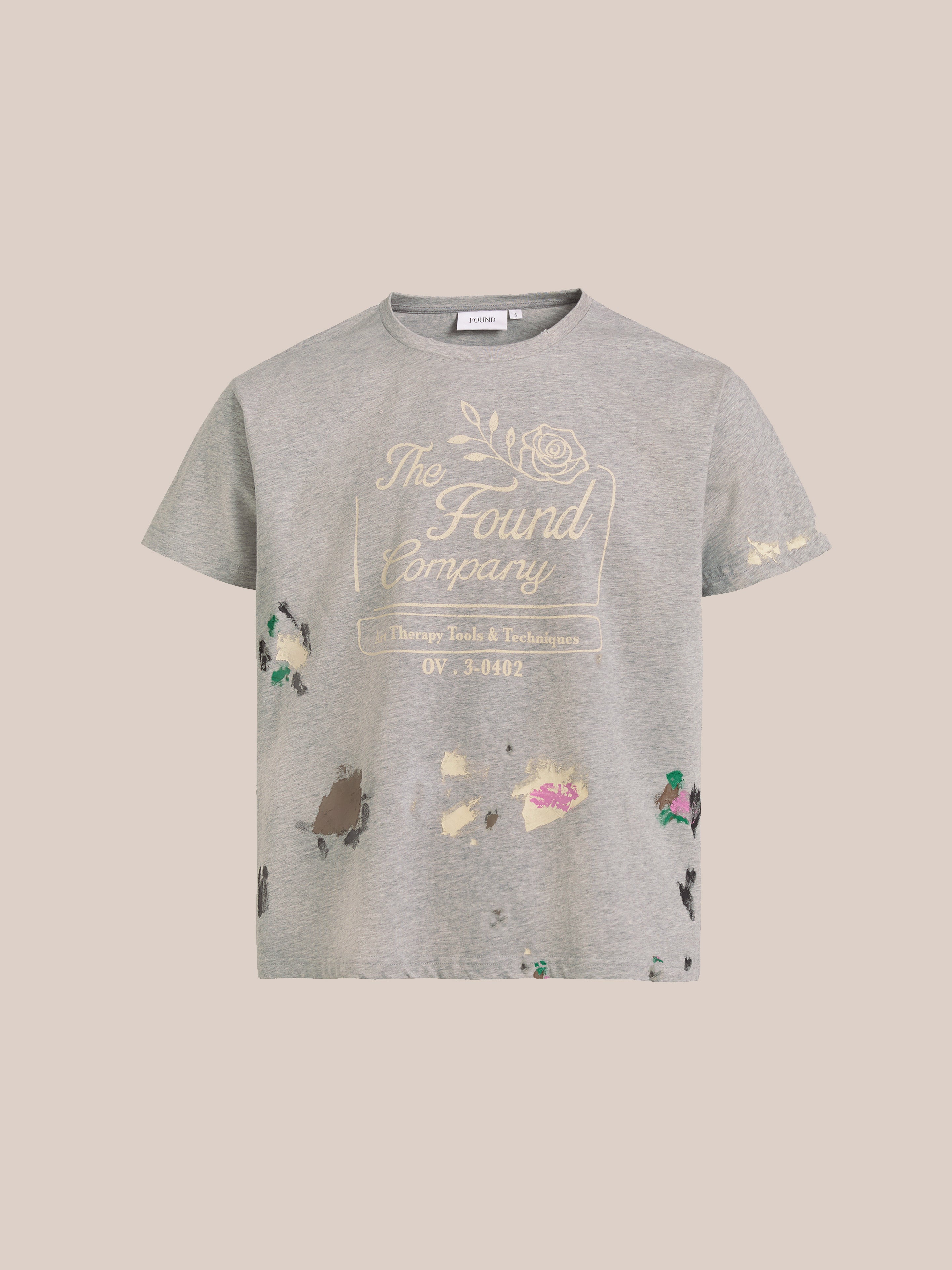 The "Painters Company Tee" from FOUND is a gray, relaxed-fit shirt with distressed paint splatters, a white "The Found Company" text design, and a vintage-style rose graphic.